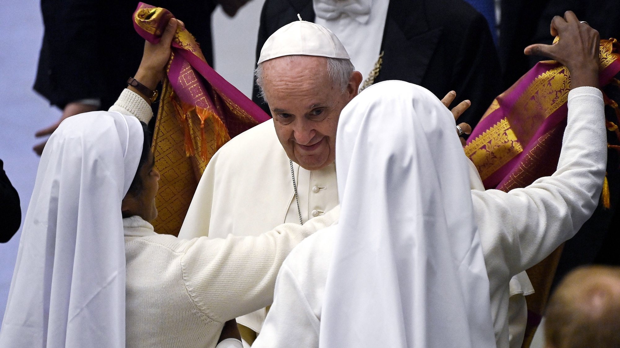 epa09659369 Pope Francis receives an Indian scarf as a gift by two nuns during his weekly General Audience in the Paul VI Audience Hall, Vatican City, 29 December 2021.  EPA/Riccardo Antimiani