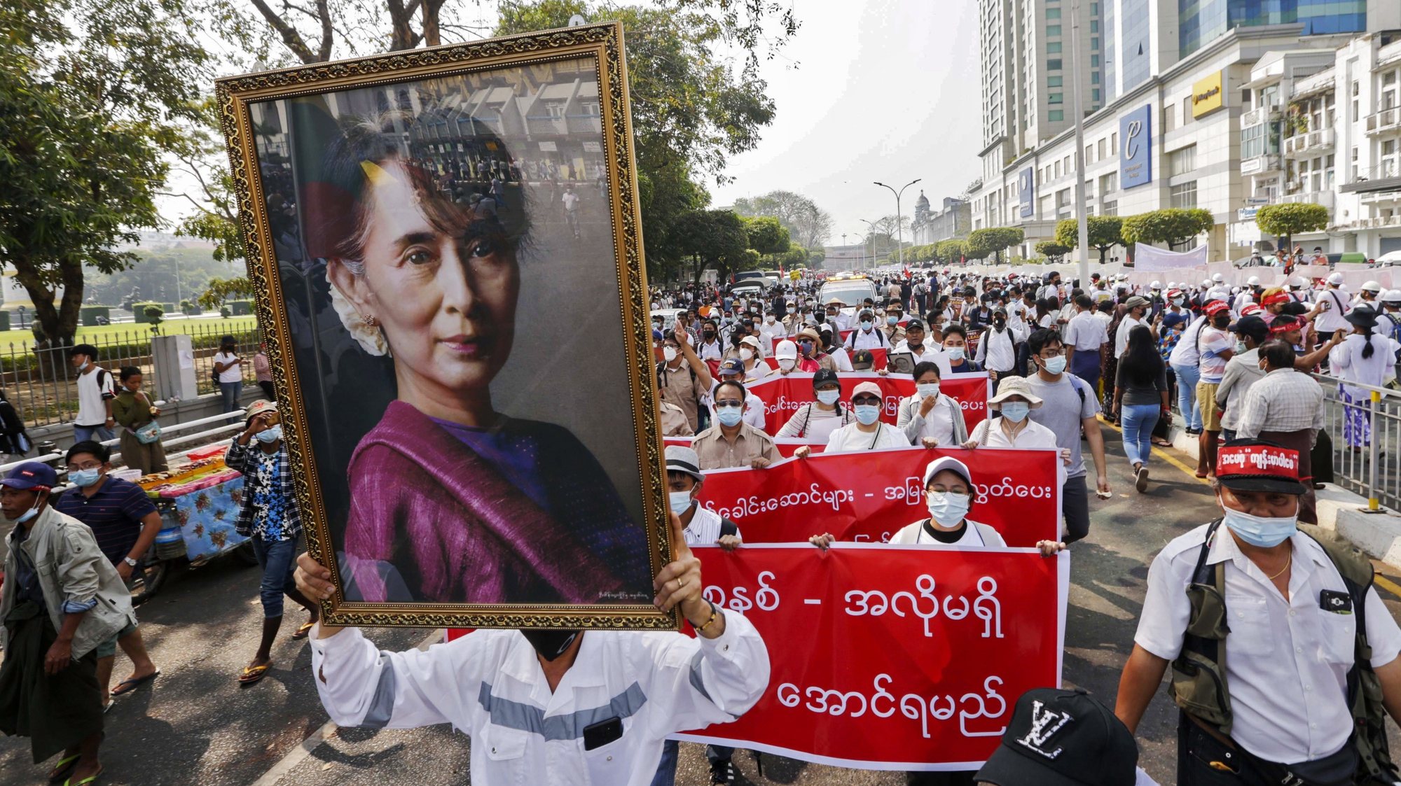 epaselect epa09029004 Demonstrators hold a portrait of detained civilian leader Aung San Suu Kyi during a protest against the military coup, in Yangon, Myanmar, 22 February 2021. Businesses closed and thousands of anti-coup demonstrators took to the streets for a nationwide general strike dubbed the &#039;22222&#039; or &#039;Five Twos&#039; uprising, in reference to the date, 22 February 2021, despite the military junta warned of lethal force.  EPA/LYNN BO BO