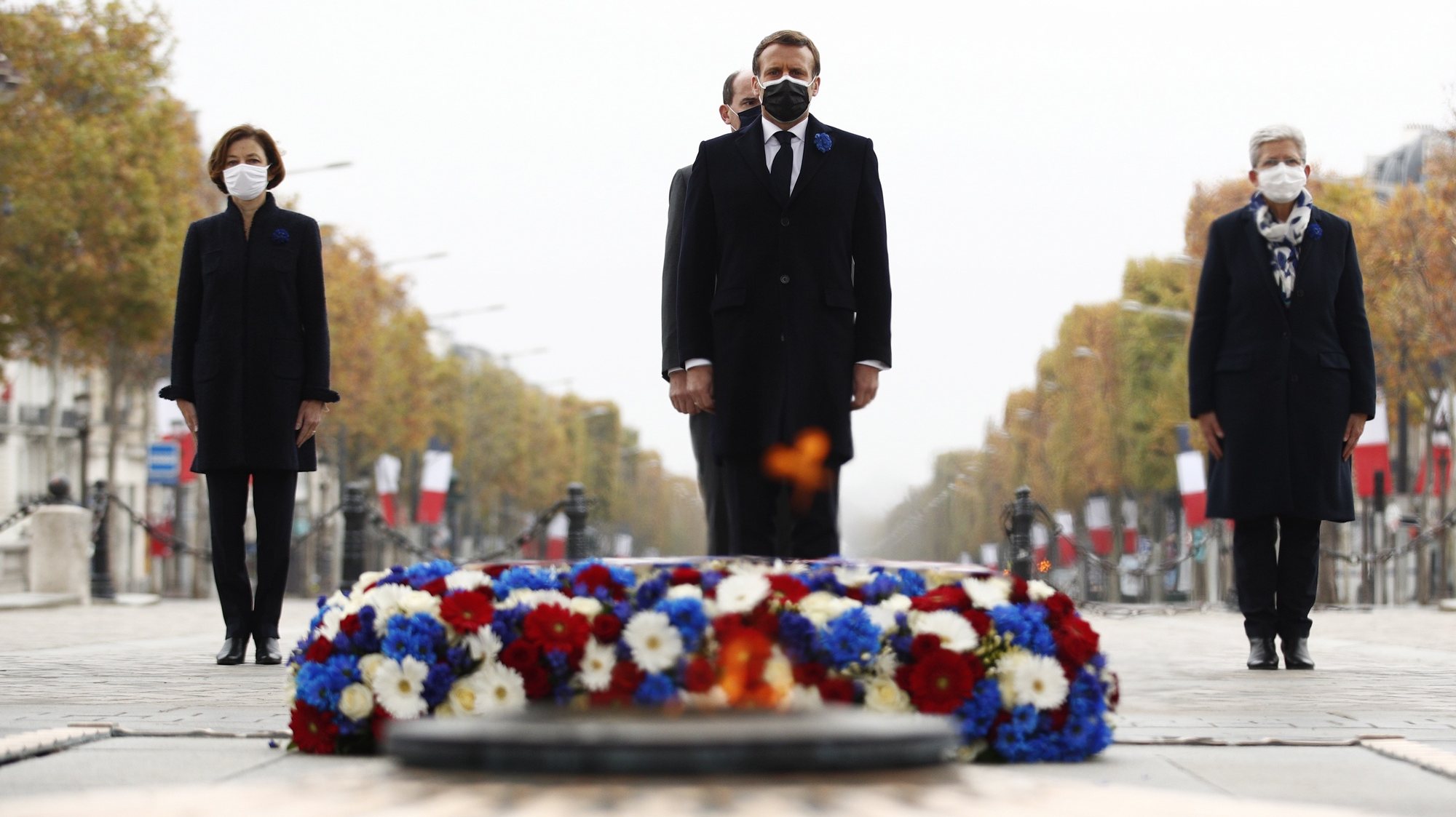 epa08812956 French President Emmanuel Macron (C) pays his repsects as French Prime Minister Jean Castex (rear C), French Junior Defence Minister Genevieve Darrieussecq (R) and French Defence Minister Florence Parly (L) stand behind during a ceremony at the Arc de Triomphe in Paris, France, 11 November 2020, as part of the commemorations marking the 102nd anniversary of the 11 November 1918 armistice, ending World War I (WWI).  EPA/YOAN VALAT / POOL