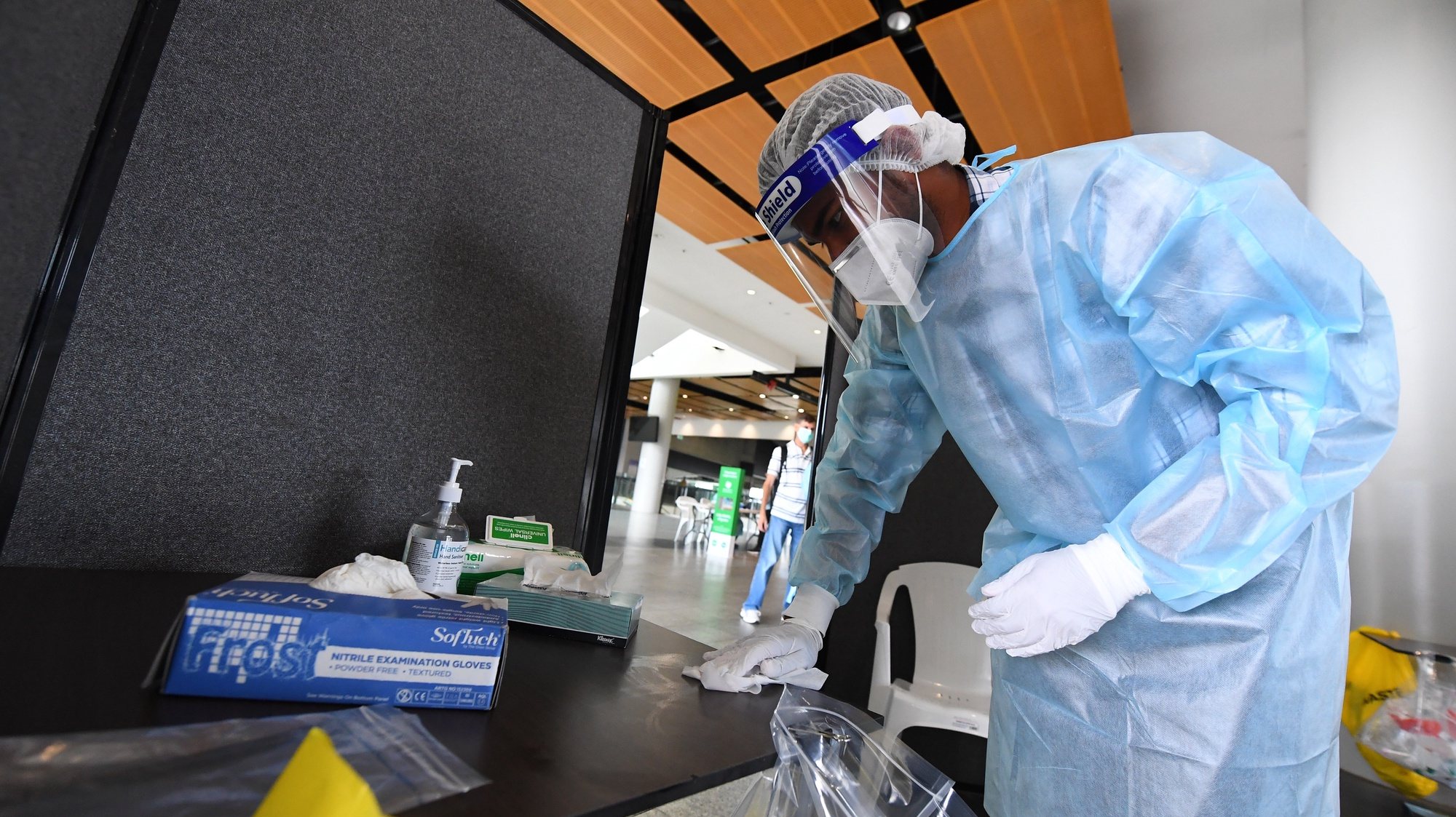 epa08921385 A healthcare worker sanitizes a table at a coronavirus testing facility at the MCG stadium in Melbourne, Australia, 06 January 2021. The MCG has been listed as a potential location for a recent cluster of COVID-19 infections after a man attended day two of the Boxing Day Test and later tested positive to coronavirus.  EPA/JAMES ROSS AUSTRALIA AND NEW ZEALAND OUT