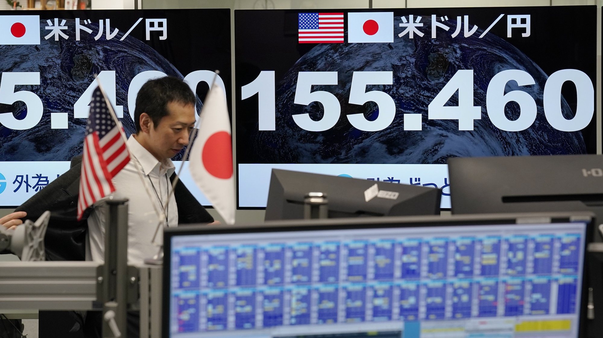 epa11299265 A money dealer returns to his seat as monitors display the foreign exchange rate of Japanese yen and US dollar in Tokyo, Japan, 25 April 2024. The exchange rate between the Japanese yen and the US dollar is falling to the mid-155 yen level. Japanese Finance Minister Shunichi Suzuki on 25 April said that the Japanese government is monitoring the foreign exchange market developments.  EPA/KIMIMASA MAYAMA