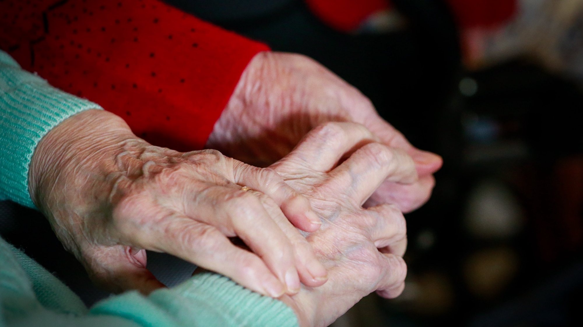 epa08786229 Two friends resident hold each other hands while they watch TV show at the &#039;Notre Dame De Bonne Esperance&#039; nursing home in Chatelet, Belgium, 30 October 2020. Due to COVID-19, residents of the nursing home are not allowed to leave among the measures taken to protect residents from the spread of coronavirus.  EPA/STEPHANIE LECOCQ