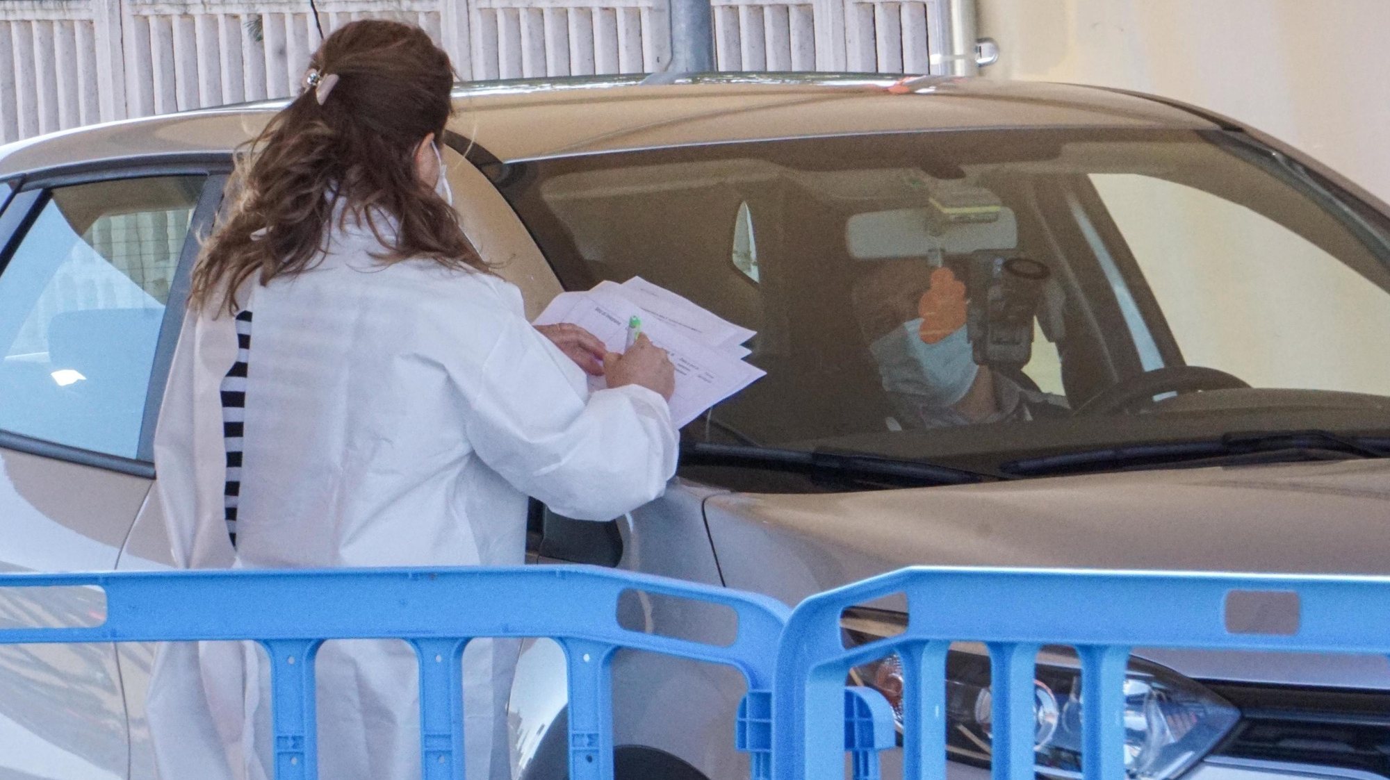 epa09132327 Medical staff await the arrival of cars at the Covid-19 drive-thru vaccination center where medical staff administer Covid-19 coronavirus vaccine injections to patients inside their vehicle in Orbassano, Turin, Italy, 13 April 2021.  EPA/JESSICA PASQUALON