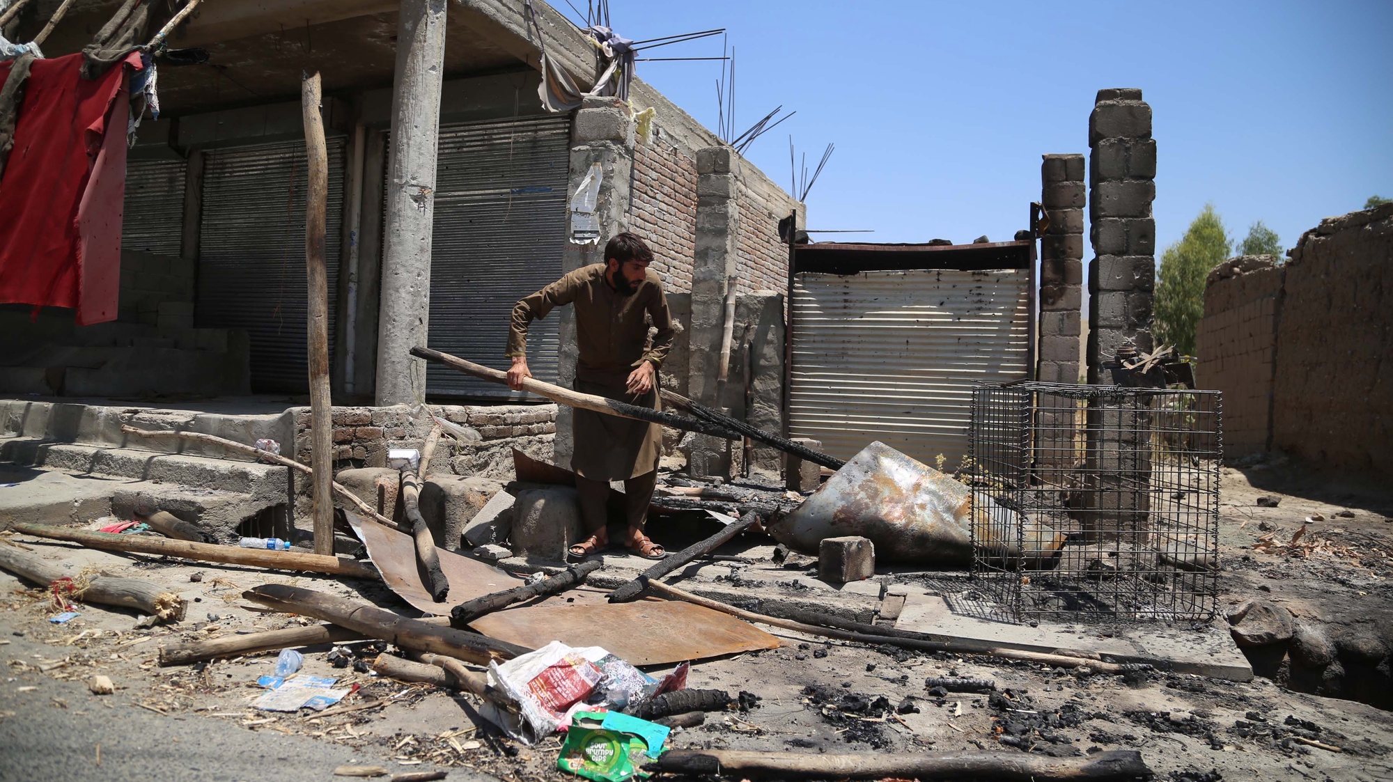 epa09330986 An Afghan man salvages his belongings from his shop that was burnt out during an operation against Taliban militants after security forces cleared the area of Taliban militants following an operation in Alishang district of Laghman province, Afghanistan, 08 July 2021. The Afghan government 06 July, confirmed that the insurgents had captured more than 100 of the countryâ€™s 400 districts, which it blamed on a lack of military support to the Afghan forces after the pullout of international troops. The United States and NATO troops began the final stages of withdrawal more than two months ago, ending a 20-year mission and handing over nearly all military bases to the Afghan army.  EPA/GHULAMULLAH HABIBI