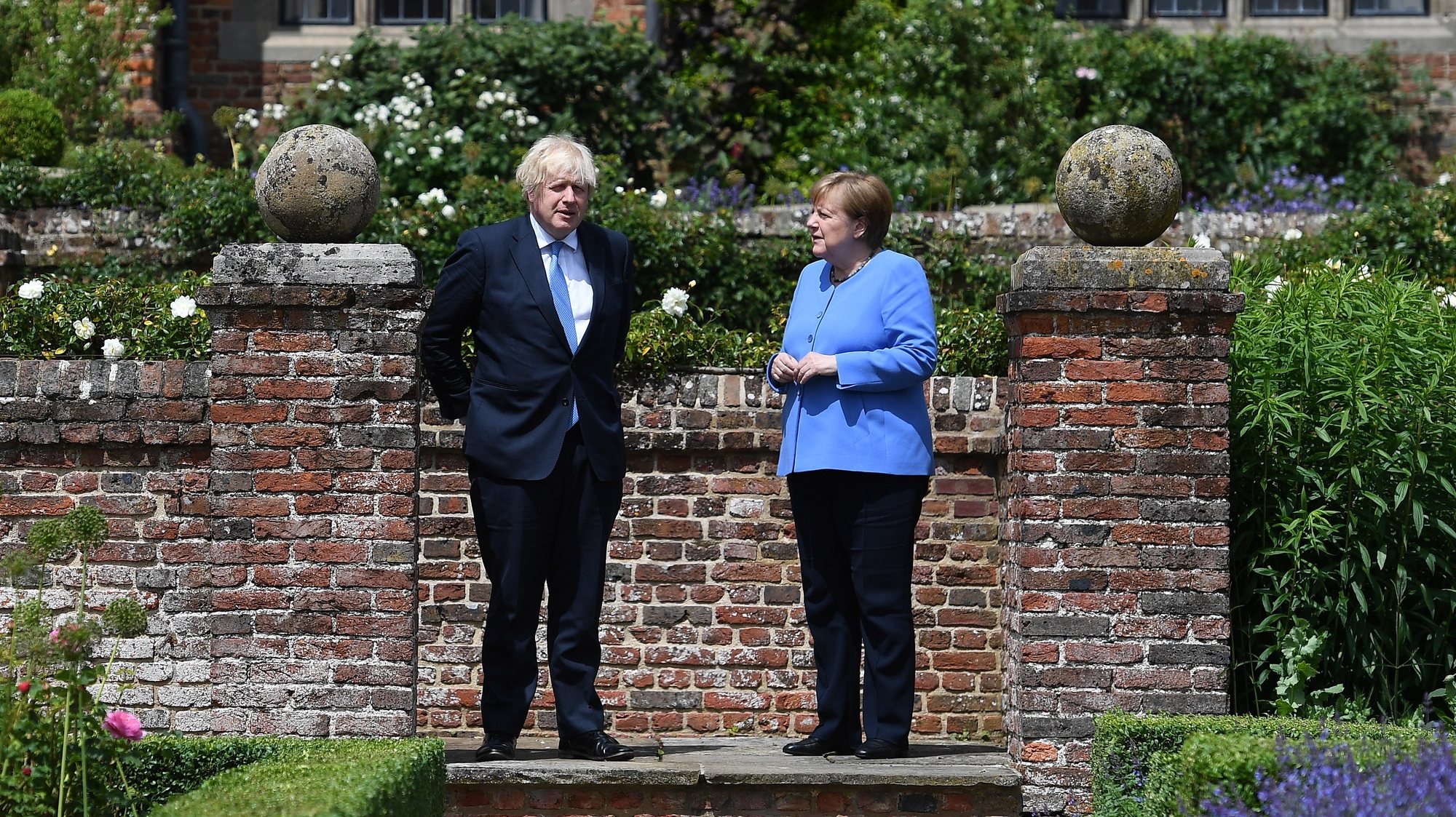 epa09317444 British Prime Minister Boris Johnson (L) with German Chancellor Angela Merkel (R) in the rose garden at the Prime Minister&#039;s country residence at Chequers, Buckinghamshire, Britain, 02 July 2021. The two nations have agreed a post Brexit  joint declaration on foreign and security policy cooperation. The bilateral agreement is the first to be struck between London and Berlin on foreign and security policy issues.  EPA/ANDY RAIN / POOL Pool