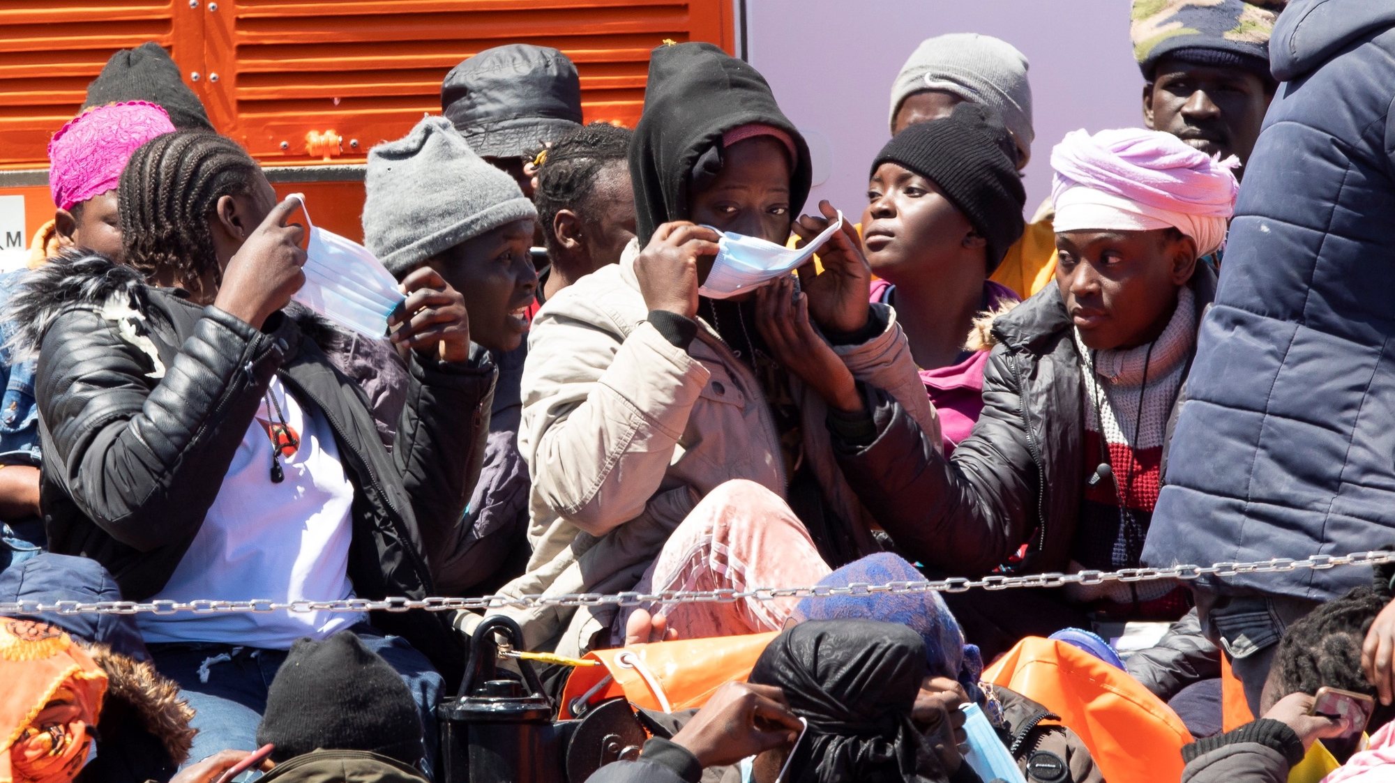 epa09168252 Some rescued migrants put on face masks upon arrival at the port of Arguineguin in Gran Canaria, Canary Islands, Spain, 29 April 2021. A total of 40 migrants were rescued by Spanish Sea Rescue Services while traveling on a small boat at sea.  EPA/QUIQUE CURBELO