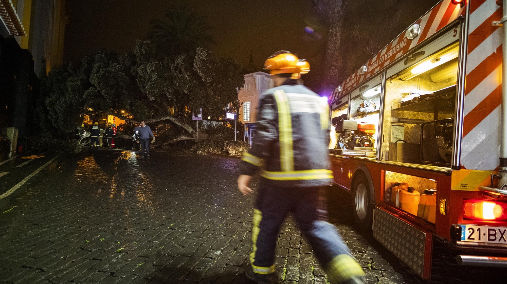 Elementos dos bombeiros e da proteção civil junto à árvore de grande porte após a queda na Rua do Marquês, devido ao mau tempo em Angra do Heroísmo, na Ilha Terceira, Açores, 27 de janeiro de 2020. ANTÓNIO ARAÚJO/LUSA