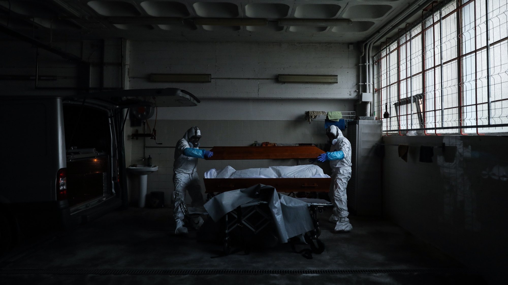 epaselect epa08347893 Employees of a funeral home fully protected with a protective suit against radioactive contamination and biological agents, close a coffin with a body of a man over 80 years old who died in his home as a victim of covid-19, in Lisbon, Portugal, 03 April 2020 (Issued 07 April 2020). Portugal is in state of emergency until 17 April 2020. Countries around the world are taking increased measures to stem the widespread of the SARS-CoV-2 coronavirus which causes the Covid-19 disease.  EPA/MIGUEL A. LOPES  ATTENTION: This Image is part of a PHOTO SET