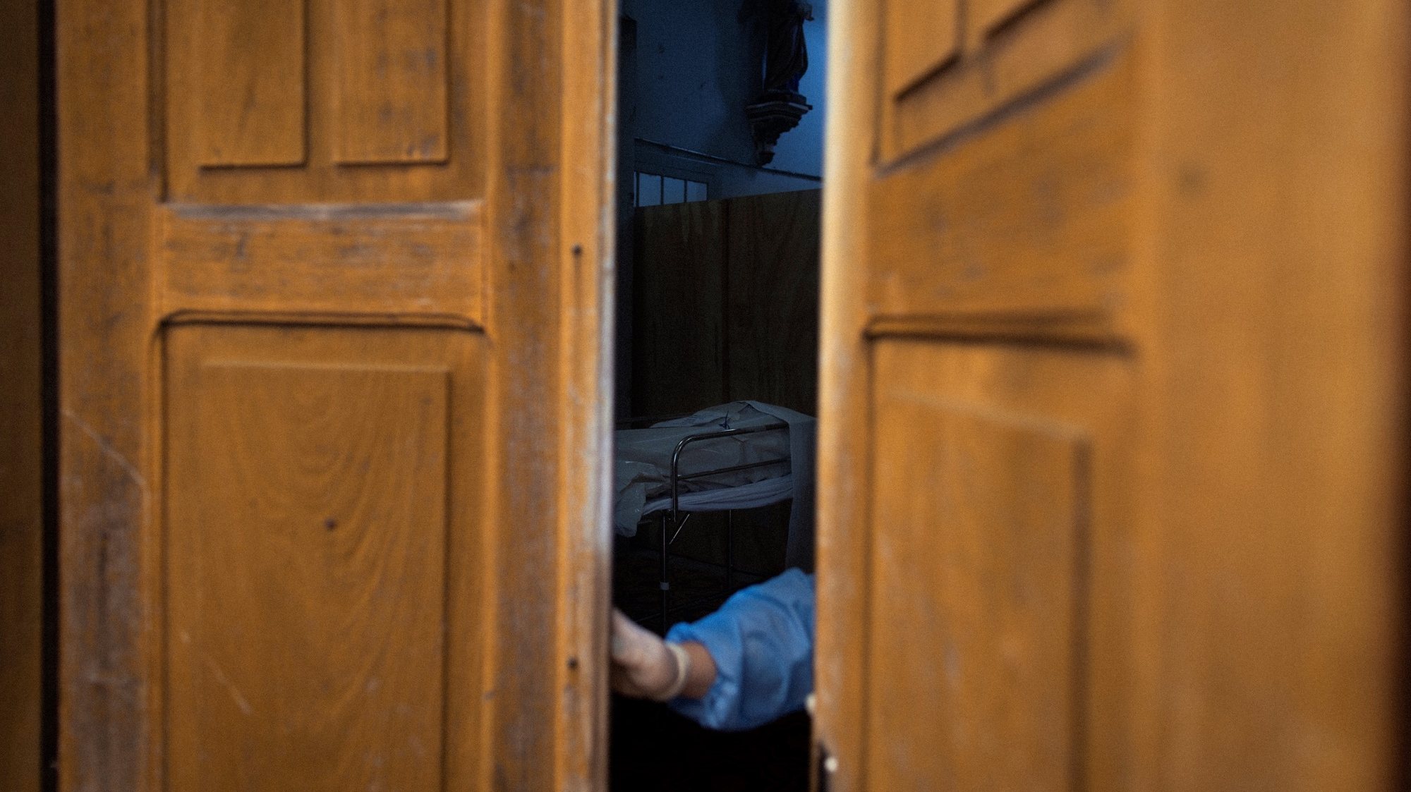epa09094355 A nurse closes the door of a makeshift morgue in the Centenario hospital church, in SÃ£o Leopoldo, Rio Grande do Sul, Brazil , 23 March 2021 (Issued 24 March 2021). The country will possibly reach the figure of 300,000 deaths on 24 March from causes related to the coronavirus. SÃ£o Leopoldo, a city in the Porto Alegre metropolitan region, has just over 230,000 inhabitants and a single municipal hospital, with 18 beds to provide intensive care to COVID-19 patients.  EPA/Daniel Marenco