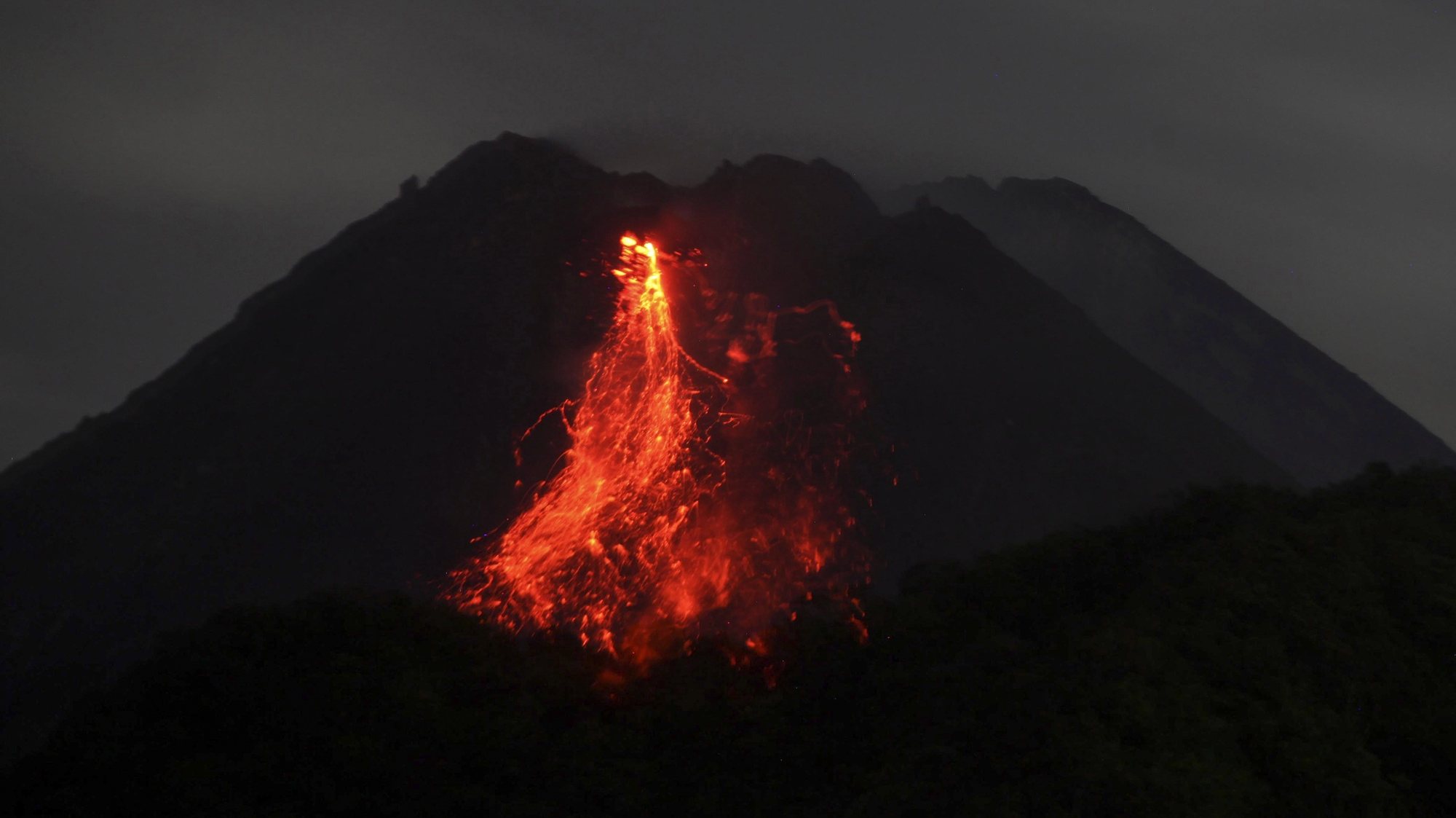 epaselect epa08945381 Mount Merapi volcano spews lava during an eruption, as seen from Sleman, Yogyakarta, Indonesia, 17 January 2021 (issued 18 January 2021). Mount Merapi is one of the most active volcanoes in the country. At least 300 people were killed when it erupted in 2010.  EPA/BOY TRIHARJANTO
