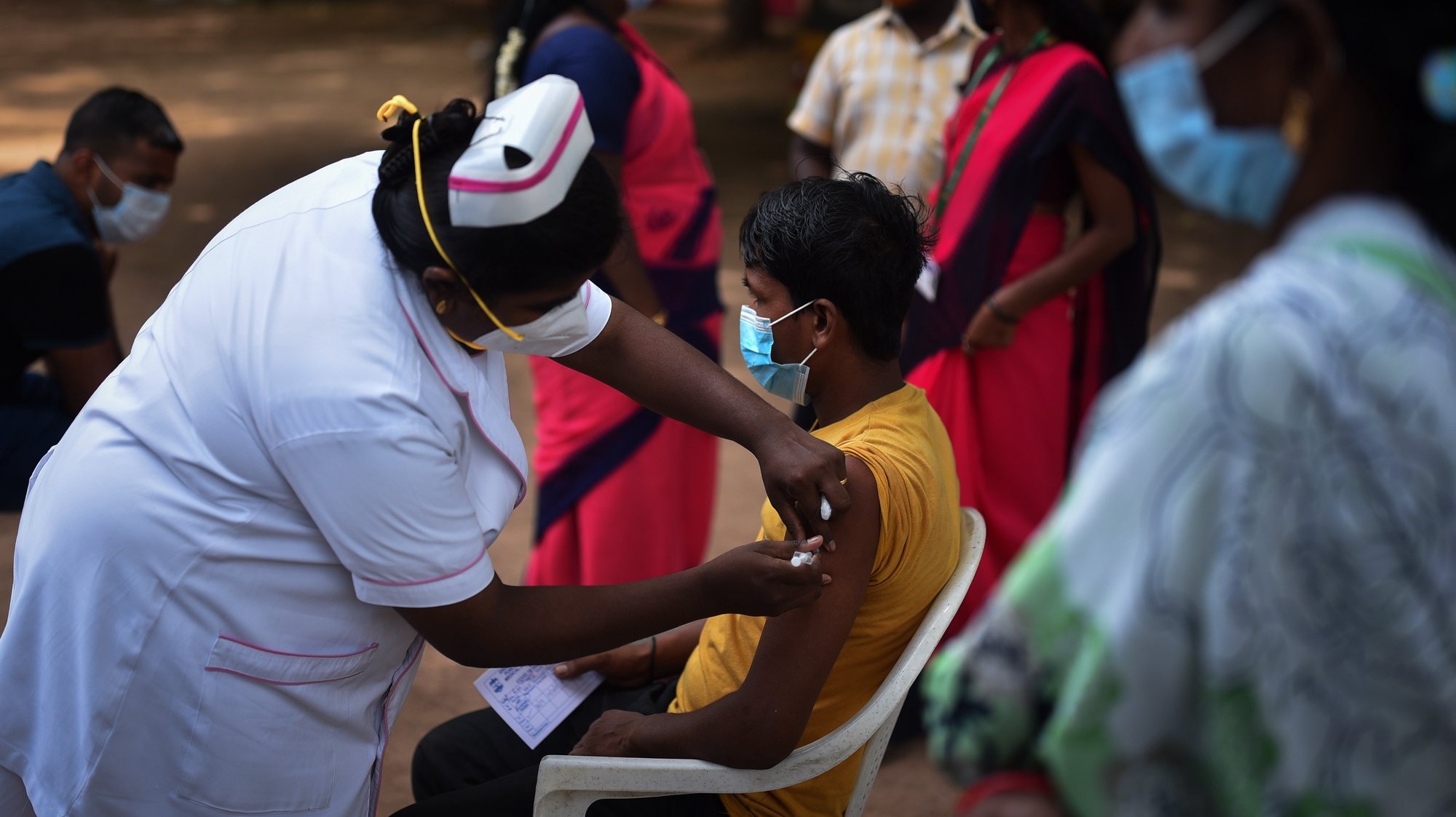 epa09463272 An Indian health worker administers a dose of COVID-19 vaccine to a man during a state wide mega-vaccination drive against the COVID-19 coronavirus, at a government school in Chennai, India, 12 September 2021. The Tamil Nadu state government organized a mega COVID-19 vaccination drive across the state for 12 hours from 7 am to 7 pm, which aims to inoculate around 2 million people above 18 years  in 40,000 government centers on 12 September 2021. The state government is conducting the mega vaccination drive to avoid the possible third COVID-19 wave. The Greater Chennai Corporation (GCC) has set-up 1600 special vaccination camps as part of the state wide mega COVID-19 vaccination drive in Chennai.  EPA/IDREES MOHAMMED