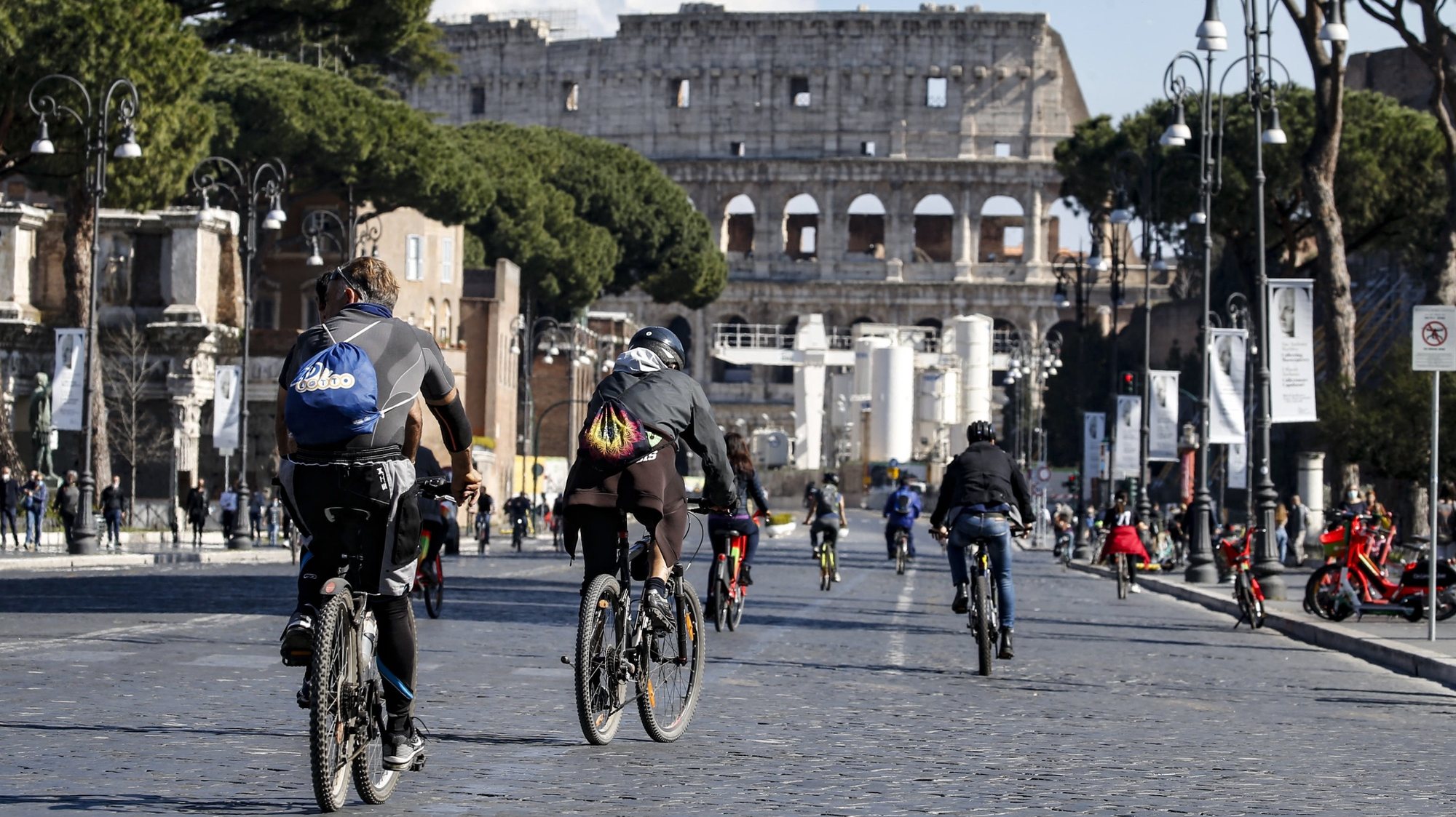 epa09103380 People riding on their bicycles in downtown during the third wave of the Covid-19 Coronavirus pandemic in  Rome, Italy, 28 March 2021.  EPA/FABIO FRUSTACI