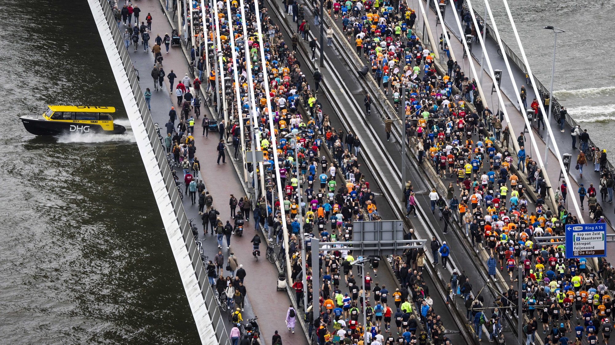 epa10575340 Athletes run across the Erasmus Bridge during the 42nd edition of the NN Marathon Rotterdam in Rotterdam, the Netherlands, 16 April 2023.  EPA/JEFFREY GROENEWEG