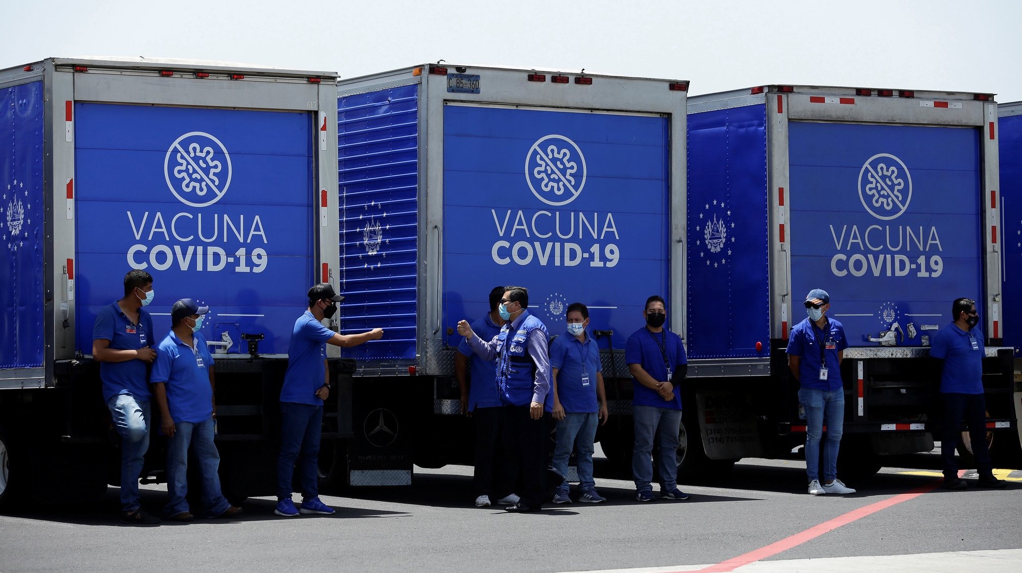 epa09358764 View of health workers next to the refrigerated trucks that will transport a batch of vaccines, sent by the United States, against COVID-19, at the San Ã“scar Romero International Airport in San Luis Talpa, El Salvador, 22 July 2021. The United States delivered a second batch of 1.5 million Modern vaccines against the SARS-CoV-2 coronavirus to El Salvador on Thursday, as part of a donation through the Covax system of the World Health Organization (WHO).  EPA/Rodrigo Sura