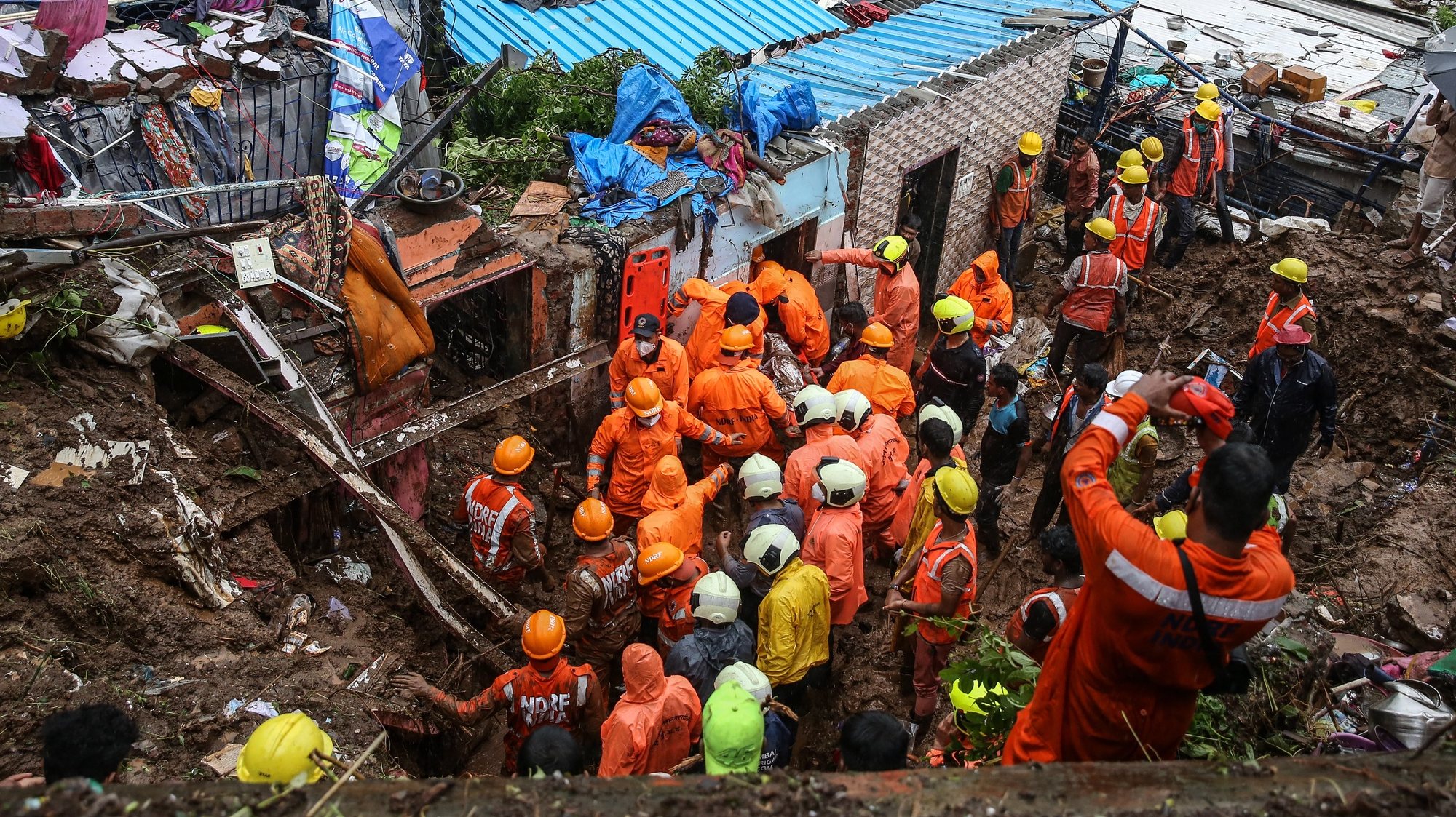 epa09352181 National Disaster Response Force (NDRF) personnel recover dead body from the rubble during a rescue operation in the aftermath of a landslide at a Bharat Nagar slum in Chembur, Mumbai, India, 18 July 2021. According to the police and municipal officials at least 22 people are dead and several others injured after a wall collapsed on some shanties in Chembur&#039;s Bharat Nagar area due to a landslide after heavy rainfall in the city.  EPA/DIVYAKANT SOLANKI