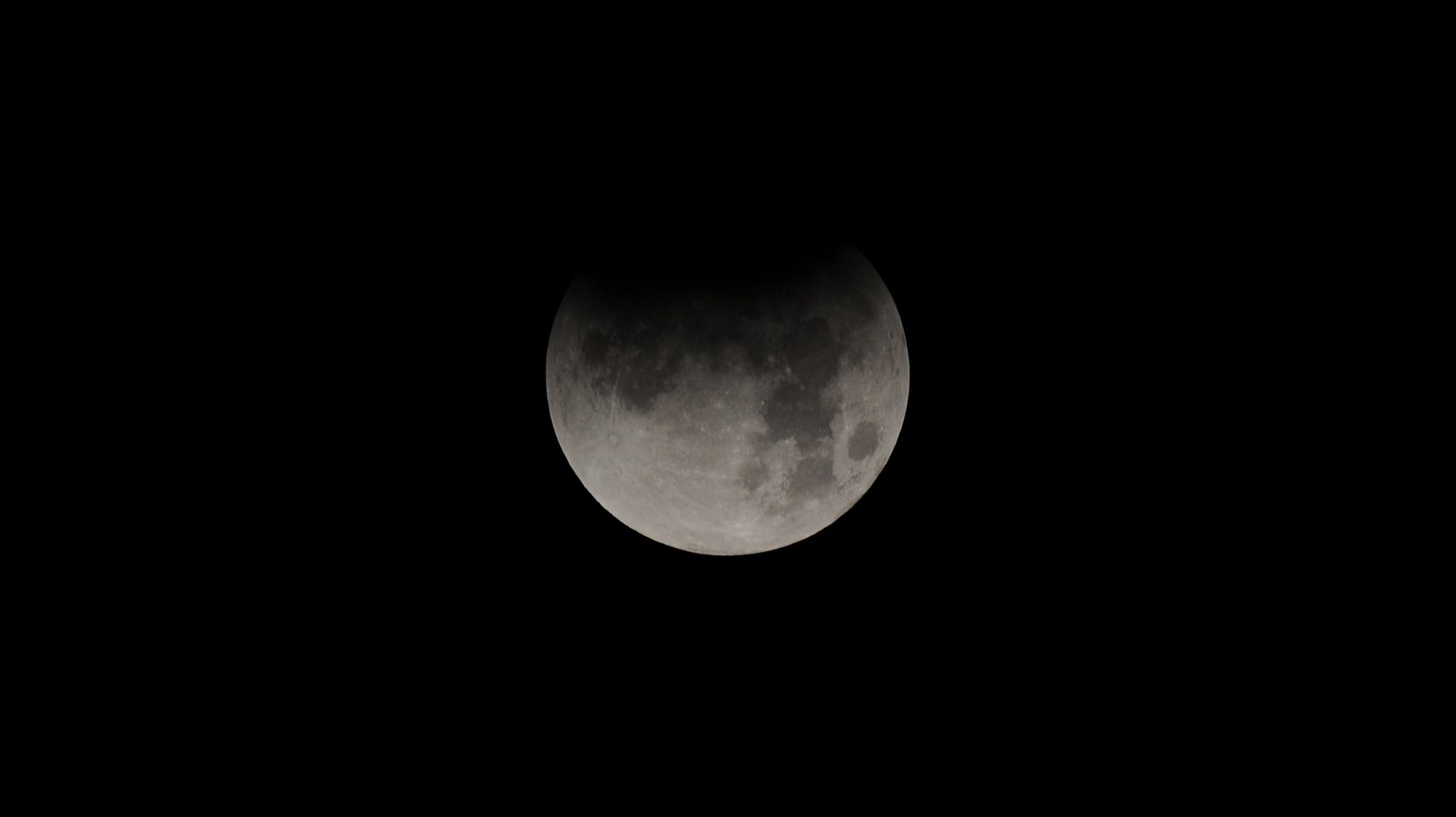Um eclipse parcial da Lua ocorre quando o satélite penetra parcialmente no cone de sombra projetado pela Terra