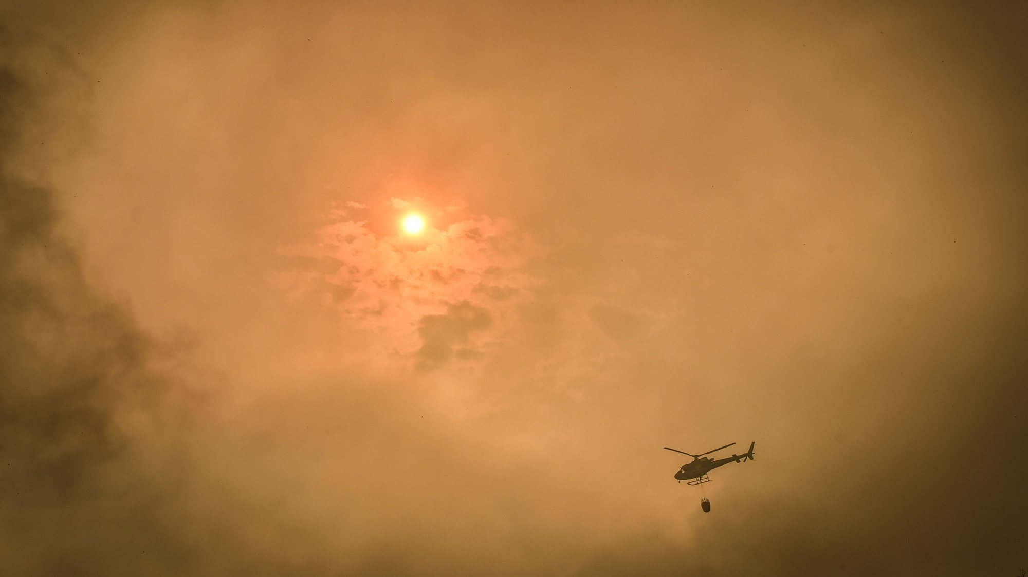 An helicopter fights a wildfire burning in the village of Aventeira, Alvaiázere, Portugal, July 12, 2022. The fire that cutted the A1 highway between Pombal and Leiria and surrounded the village of Aventeira (Alvaiázere) has 350 operatives, supported by 103 vehicles and two aircraft. NUNO ANDRE FERREIRA/LUSA
