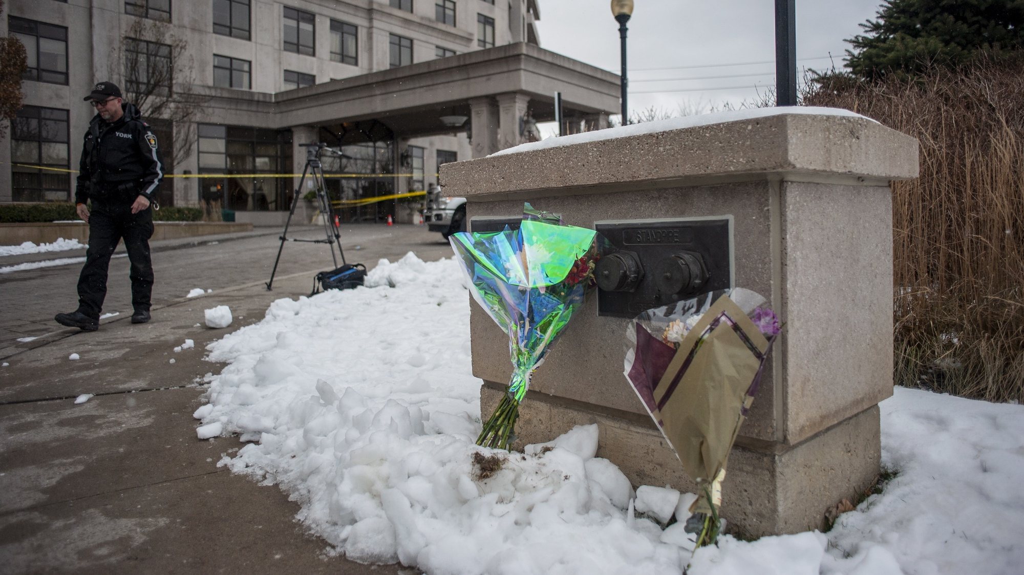 epa10374134 Flowers are seen in front of the condominium where a man allegedly shot and killed five people and later was killed by police in Vaughan,  near Toronto, Canada, 19 December 2022.  EPA/EDUARDO LIMA