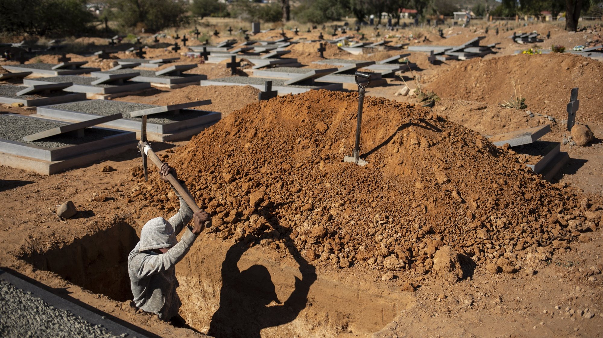 epa08493497 (03/28) Local grave digger Romio Bardman digs another grave in the town&#039;s graveyard in Graaff Reinet, South Africa, 12 June 2020. Romio has seen three Covid-19 victims buried in this graveyard. People who died with the coronavirus have to be buried within three days of dying. Romio usually digs graves the depth of his shoulders but has to dig coronavirus graves above his head. 
In the barren expanses of the Karoo (Great dry land) in the Eastern Cape province of South Africa, a perfect storm of circumstances has had a major and devastating effect on the local people. Three months of Covid-19 coronavirus lockdown, a harsh seven-year drought, and the ongoing impact of the general economic slowdown over the past years along with an ill-prepared local and provincial government have left the vast majority of the local people under financial, physical and spiritual pressure.  EPA/KIM LUDBROOK    ATTENTION: For the full PHOTO ESSAY text please see Advisory Notice epa08493494