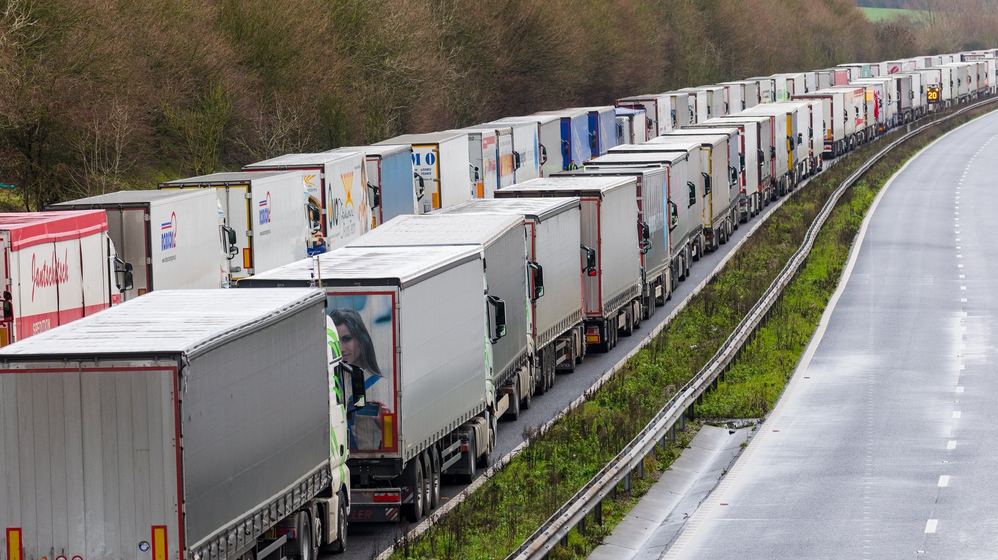 epaselect epa08901084 Queues of stationary lorries on the M20 motorway between Ashford and Folkestone in Kent, Britain, 23 December 2020. France closed its border with the UK for 48 hours over concerns about the new coronavirus variant. Lorry drivers must now obtain negative coronavirus tests before they will be allowed to cross by sea and the Port of Dover remains closed to outbound traffic on the morning of 23 December 2020.  EPA/VICKIE FLORES