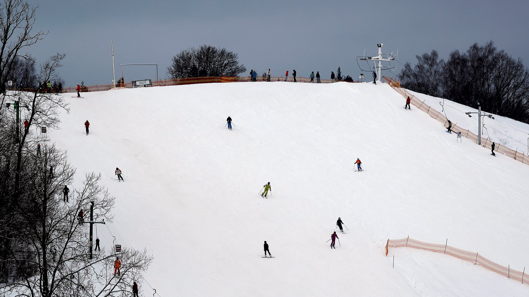 epa08935340 People enjoy downhill skiing in Zagarkalns, Cesis, Latvia, 13 January 2021. As a winter started a few downhill skiing centers are opened to the public with the limited numbers of clients who should book their time of atendance online in advance.  EPA/TOMS KALNINS