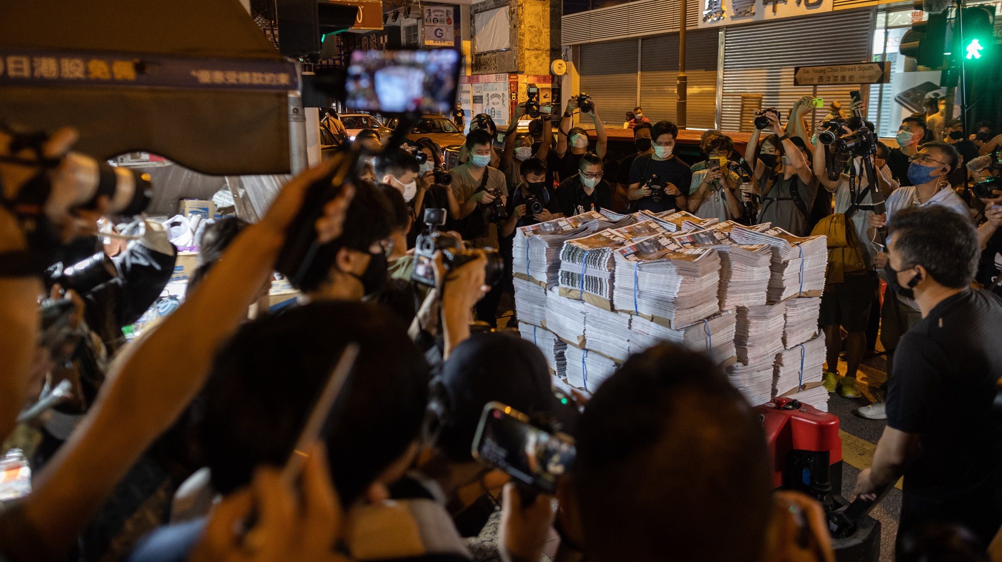 epa09296913 Supporters and members of the media surround a palette of Apple Dailyâ€™s final issue being delivered to a newsstand in the early hours to buy Apple Dailyâ€™s final issue in Mongkok district, Hong Kong, China, 24 June 2021. The last edition of Apple Daily rolled off the presses three days earlier than expected, after management took into consideration the safety of its staff and manpower concerns.  EPA/JEROME FAVRE