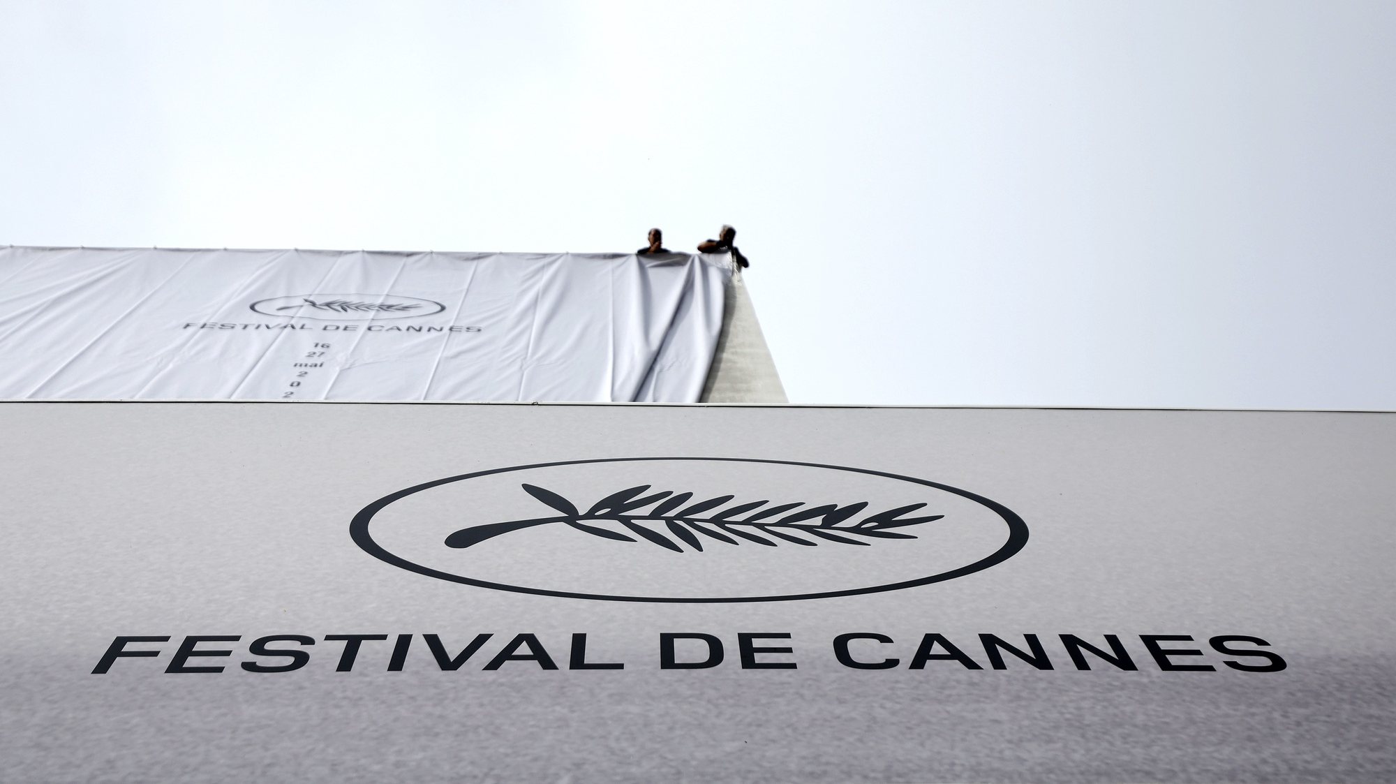 epa10626669 Workers set up the official poster of the 76th annual Cannes Film Festival on the Palais des Festivals facade in Cannes, France, 14 May 2023. The festival runs from 16 to 27 May.  EPA/SEBASTIEN NOGIER