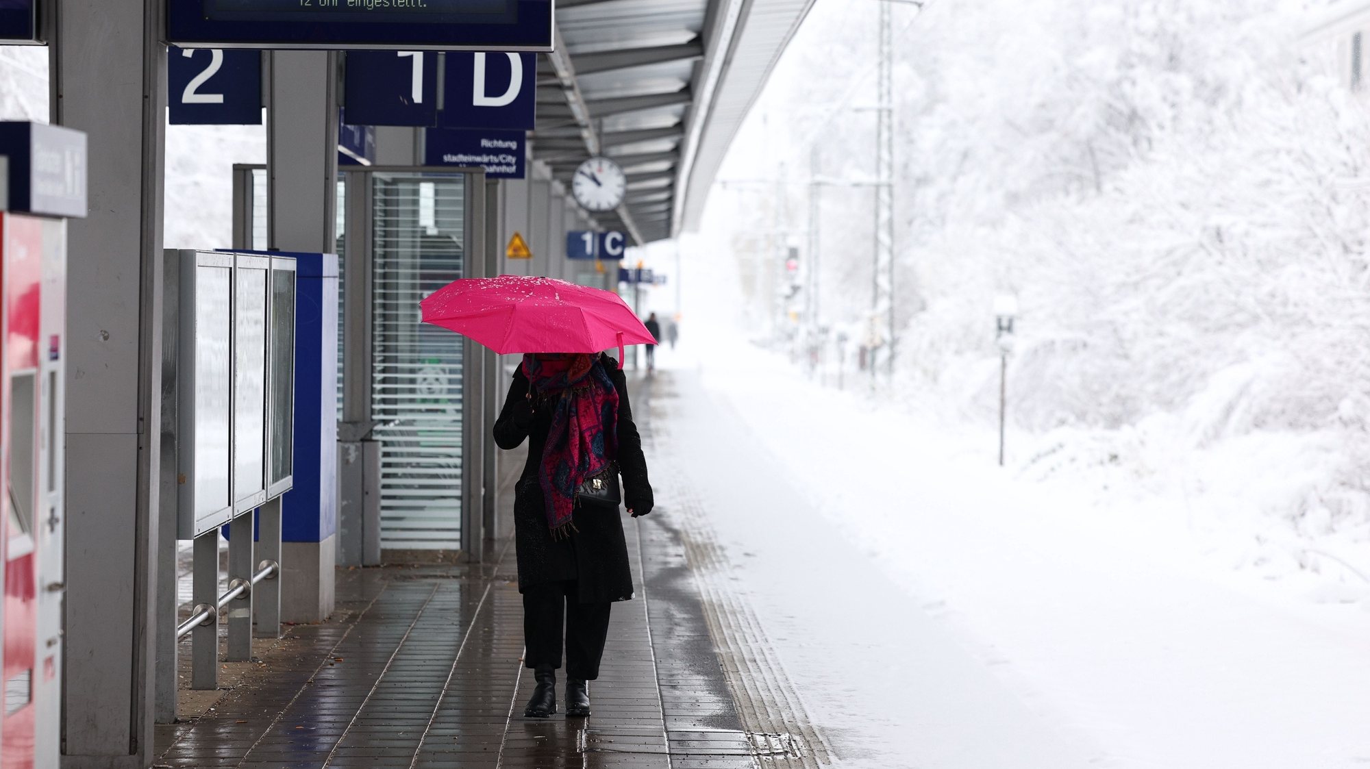 epa11007146 A woman walks along a train platform amid heavy snow in Munich, Germany, 02 December 2023. Due to heavy snowfall, flight operations at Munich Airport have been temporarily suspended until 03 December at 6 a.m., the airport announced. Several railway lines around Bavaria&#039;s state capital Munich had to be closed overnight, Deutsche Bahn (DB) said. Snowfall is expected to continue throughout the day in south and southeast Germany with as much as 20 to 40 cm of snow covering some areas of Bavaria, followed by frost and partly slippery conditions, the German Meteorological Service (DWD) warned.  EPA/ANNA SZILAGYI