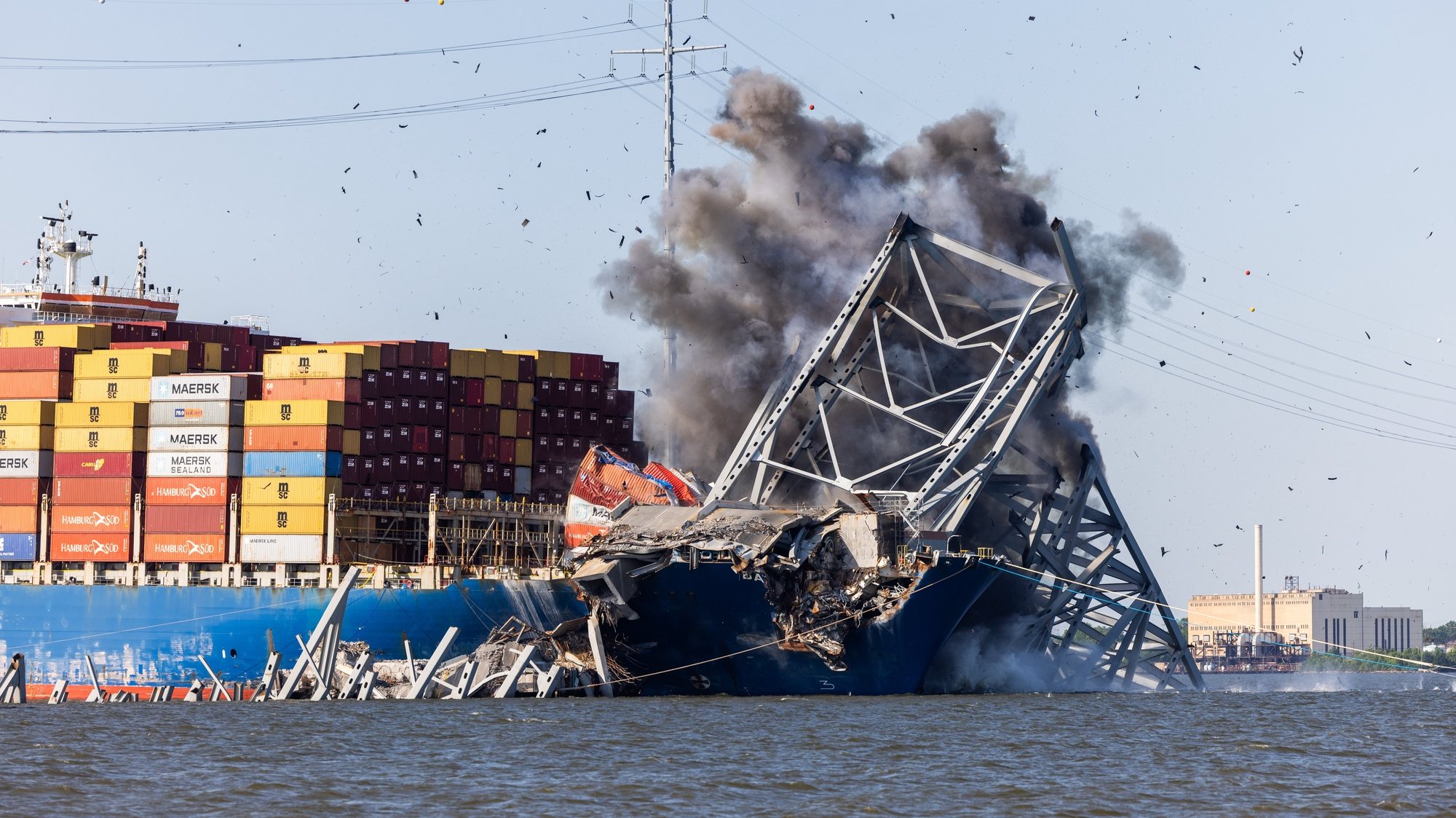 epa11338097 Engineers detonate controlled explosives to remove a steel span from the Key Bridge from the bow of the Dali container ship in Baltimore, Maryland, USA, 13 May 2024. Following the detonation, the 600-ton truss sank into the Patapsco River. Crews have been working around the clock to reopen the channel to maritime traffic since the Dali brought down the Key Bridge on 26 March.  EPA/JIM LO SCALZO