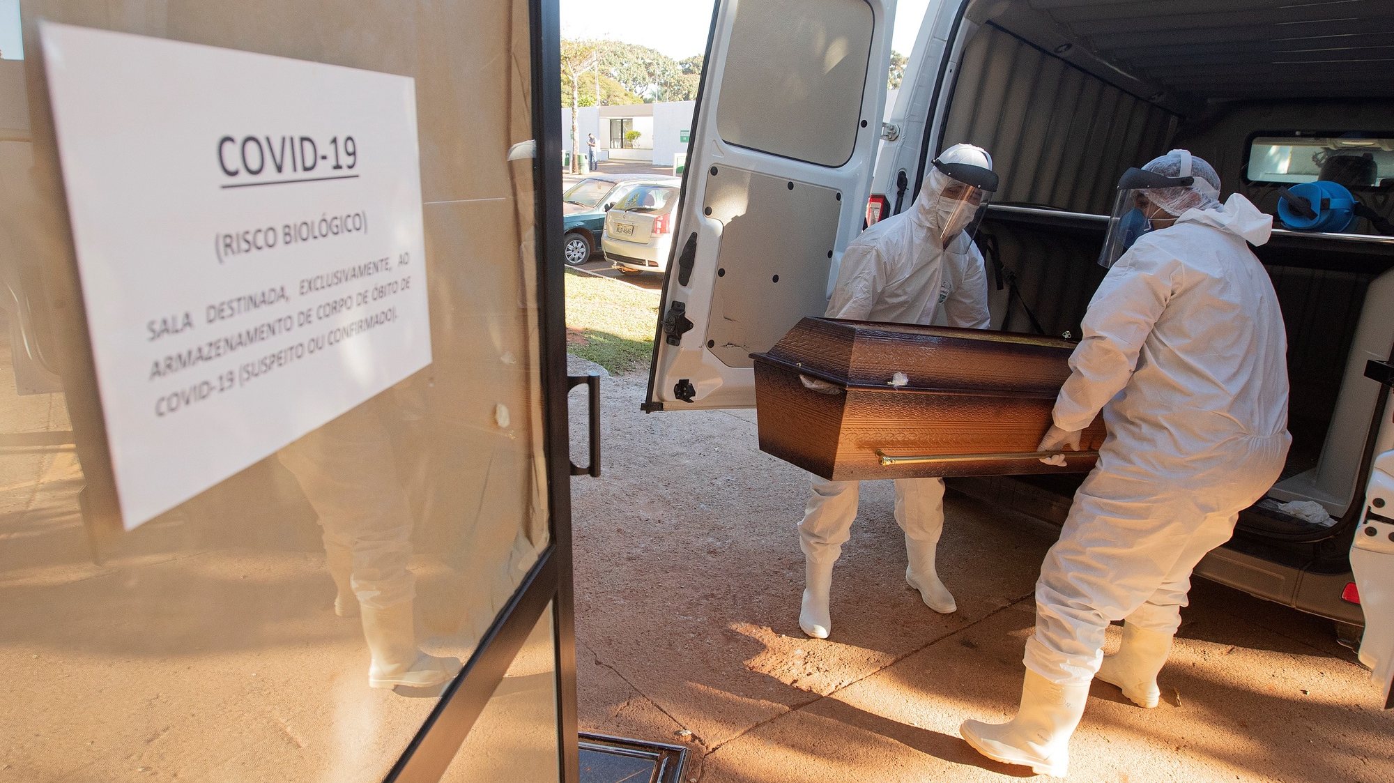 epa08477397 Funeral workers move caskets of coronavirus fatalities to a separate location, prior to burial at the Campo da EsperanÃ§a cemetery in Brasilia, Brazil, 10 June 2020.  EPA/Joedson Alves