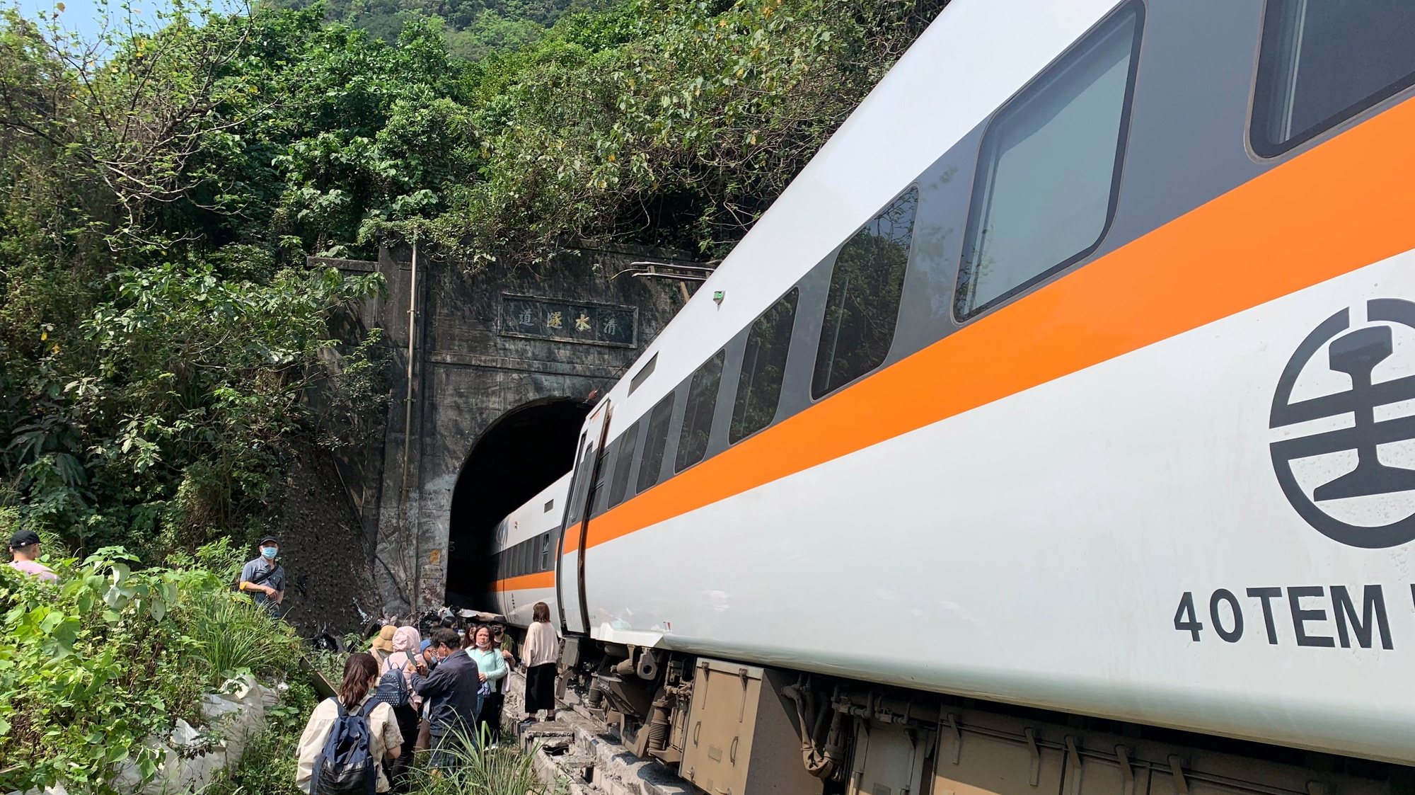 epa09111574 A handout photo made available by Taiwan&#039;s National Fire Agency shows people walking beside a train which derailed in a tunnel north of Hualien County, eastern Taiwan, 02 April 2021. At least 36 people died and many others were injured when a train carrying 350 people derailed in a tunnel north of Hualien in eastern Taiwan on 02 April.  EPA/Taiwan National Fire Agency HANDOUT  HANDOUT EDITORIAL USE ONLY/NO SALES