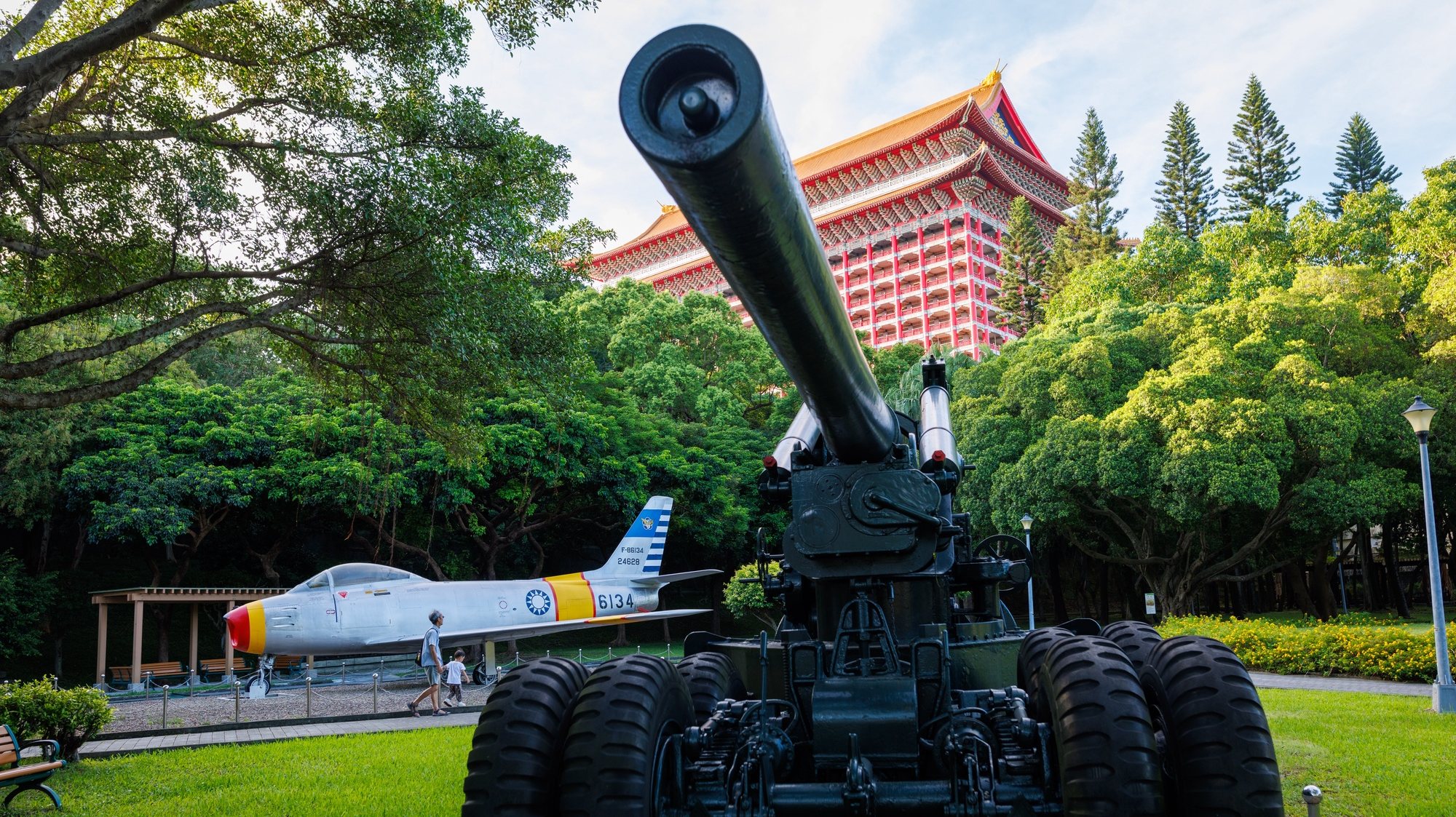 epa10819403 Taiwanese people walk past an old m59 155MM cannon and F-86 jet fighter at the 823 Artillery Battle Memorial Park, in Taipei, Taiwan, 25 August 2023. The Taiwanese defense ministry reported increased Chinese military activities near the island, including the entry of 13 planes into Taiwan&#039;s ‘response’ zone and the patrolling of five ships for combat readiness. According to the government&#039;s announcement on 24 August, Taiwan will spend an additional 2.97 billion US dollars on weapons, including fighter jets, to enhance its defenses against China.  EPA/RITCHIE B. TONGO