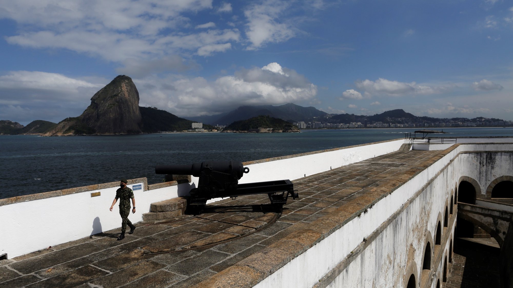 epa09404428 A man visits the Santa Cruz da Barra fort, with Rio de Janeiro seen in the background, in Niteroi, Brazil, 07 August 2021. Rio de Janeiro currently has three items on the UNESCO World Heritage List; now, the city promotes the inclusion of two fortresses, Santa Cruz da Barra and Sao Joao, built during colonial times.  EPA/Antonio Lacerda