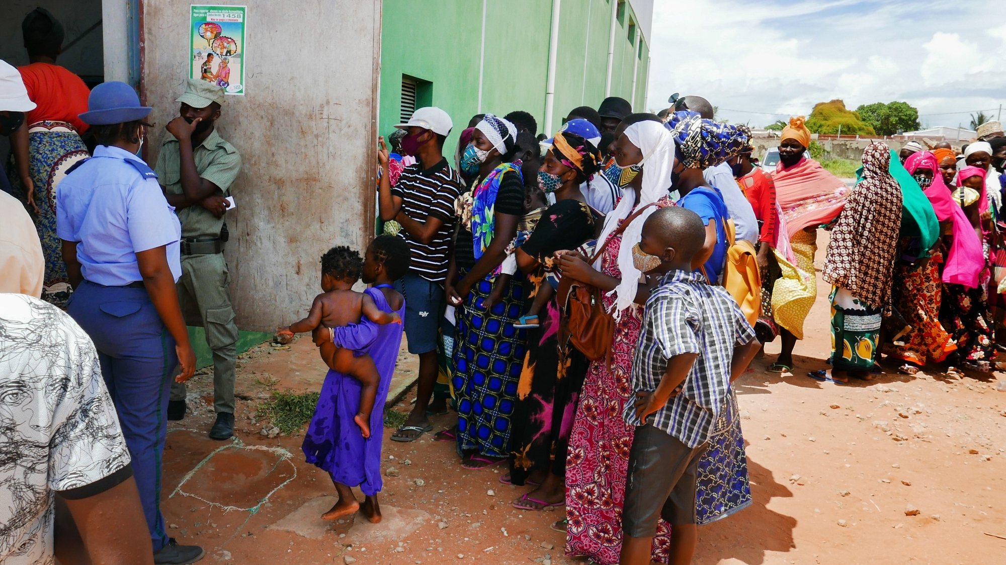 Vários deslocados de Palma à porta do centro de abrigo temporário onde o pavilhão que continua a ser um campo de jogos, mas agora de crianças refugiadas da guerra, cujas famílias não têm ninguém para contactar em Pemba e por isso dispõem de abrigo temporário em locais como este, Pemba, Moçambique, 02 de abril de 2021. LUÍS MIGUEL FONSECA/LUSA