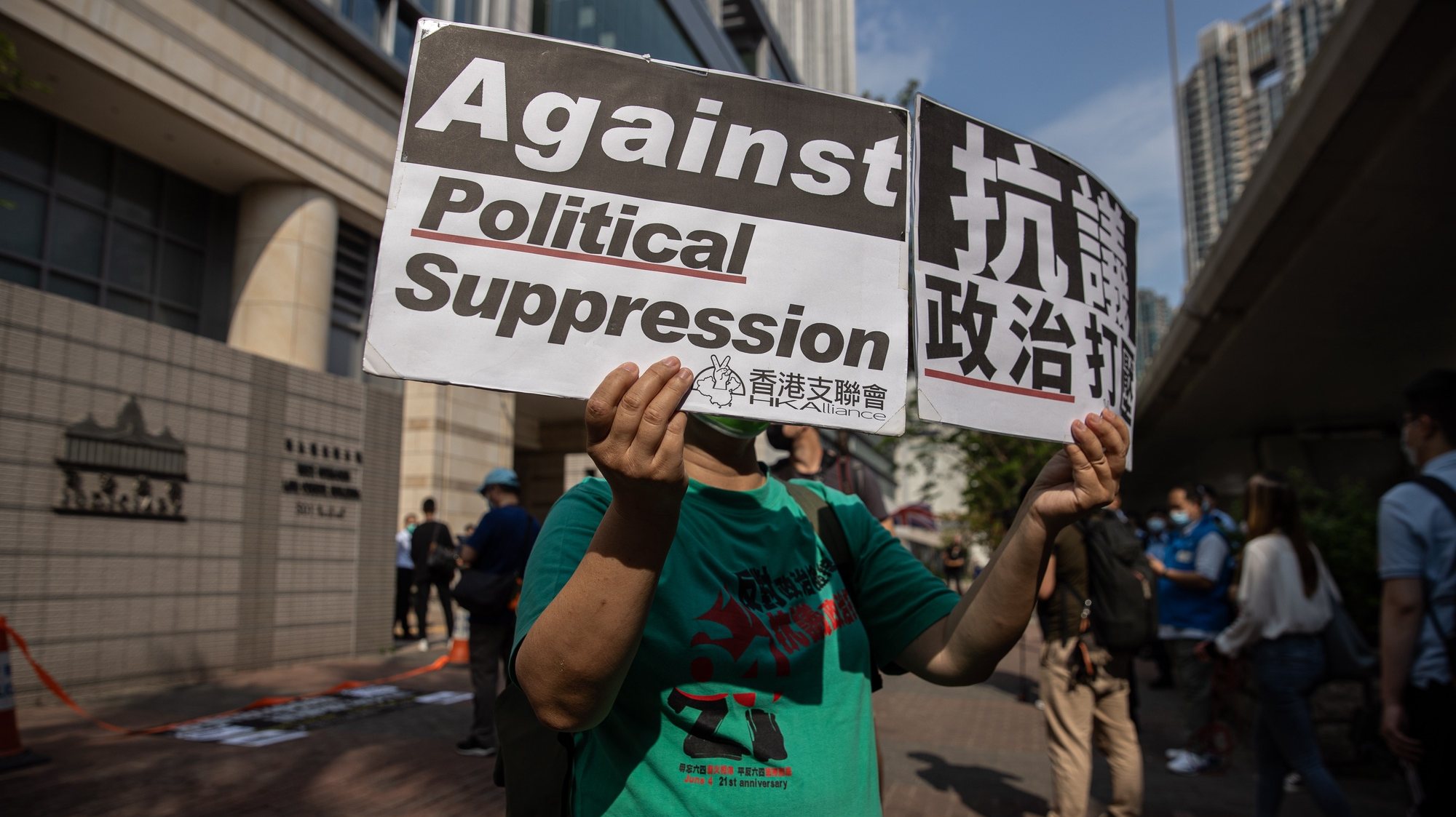 epa09109807 A pro-democracy activist holds banners outside the West Kowloon court buildings in Hong Kong, China, 01 April 2021. Nine democracy activists face verdict on 01 April for unauthorized assembly in August 2019.  EPA/JEROME FAVRE