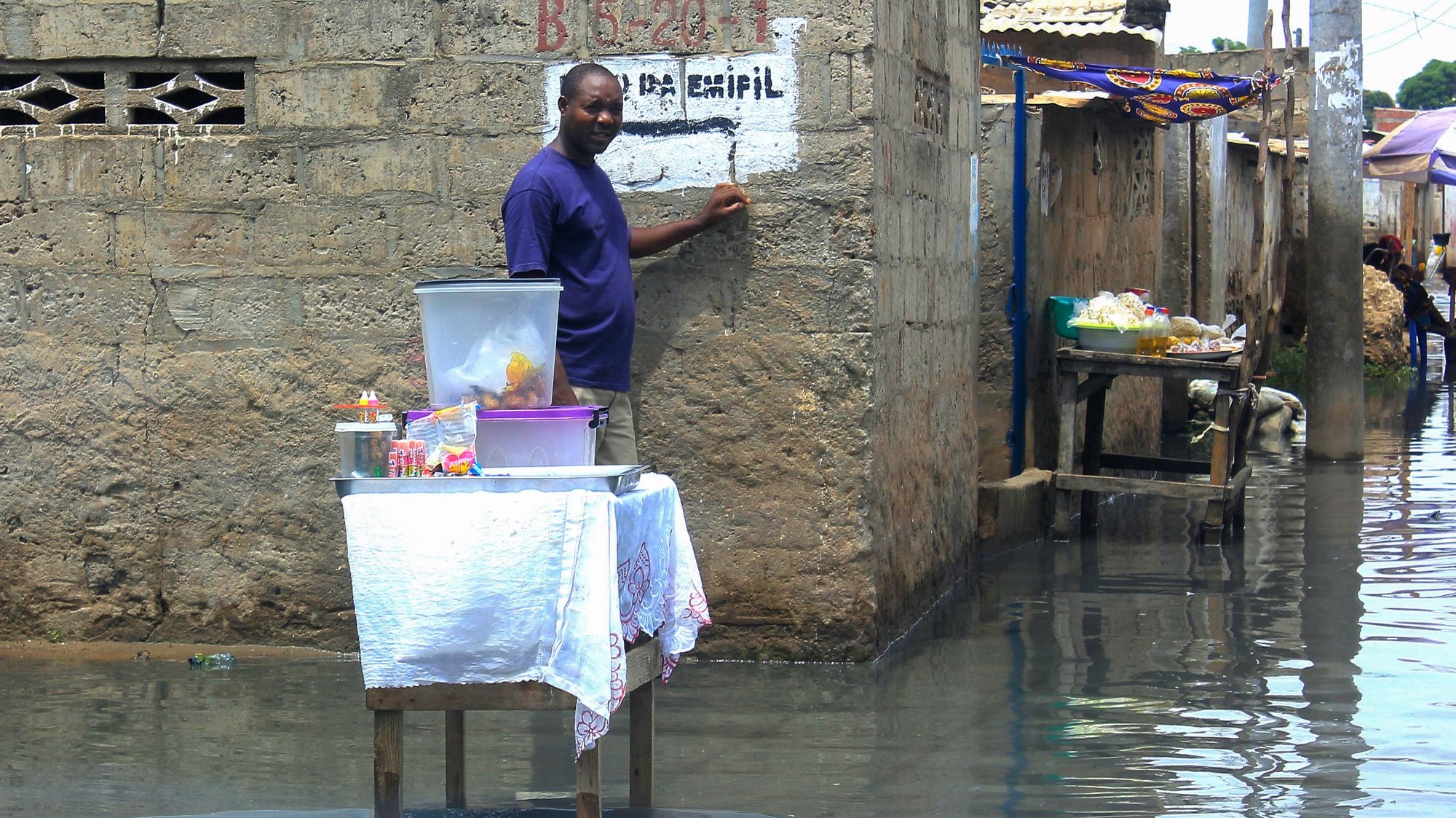 Um vendedor ambulante vende os seus produtos numa rua alagada do Bairro da Boa Esperança após a queda de chuvas fortes na capital angolana, Luanda, Angola, 9 de abril de 2019.  AMPE ROGÉRIO/LUSA