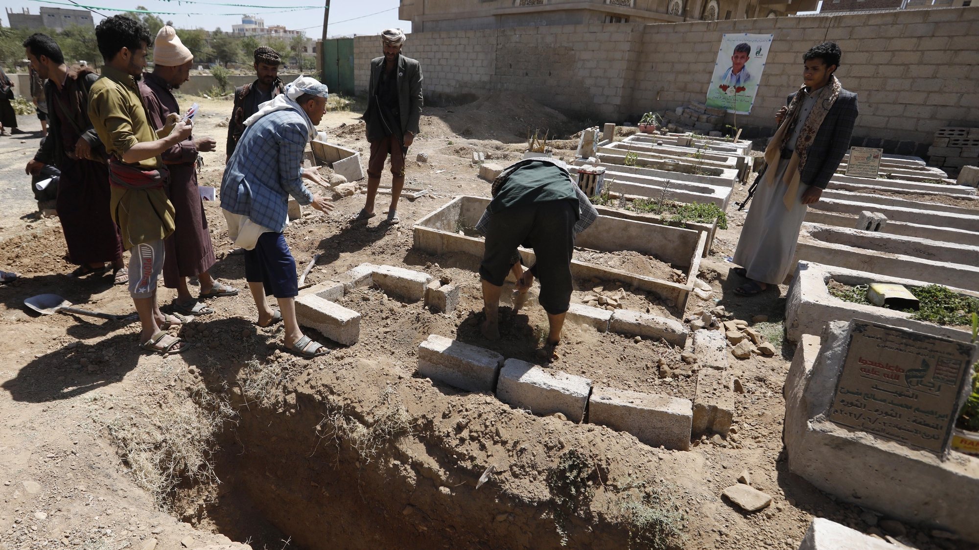 epa09527254 Yemenis bury the body of a slain Houthi fighter near a freshly dug grave during a funeral at a cemetery dedicated to slain Houthi fighters, in Sana&#039;a, Yemen, 16 October 2021. Saudi-led coalitionâ€™s airstrikes have allegedly targeted Houthi reinforcements heading to the front lines in the Yemeni province of Marib, killing more than 180 Houthi fighters in the past two days as the Houthis intensify their offensive in quest for control of the oil-rich province, the Yemeni government&#039;s last northern stronghold. The UN has estimated that at least 235 civilians were killed or injured during hostilities in Yemen in September 2021, the second highest monthly death toll in two years of ongoing conflict and the Saudi-led bombing campaign.  EPA/YAHYA ARHAB