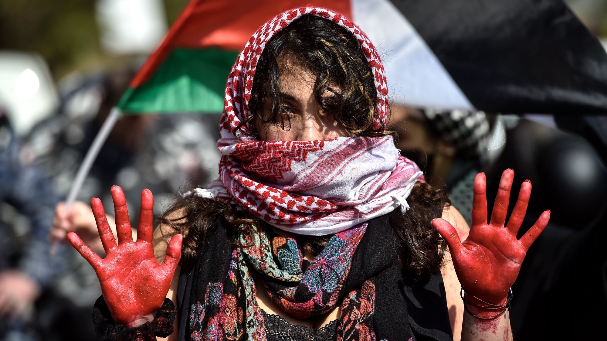 epa11165917 An activist raises her red-painted hands during a protest to demand the opening of Rafah border crossing between Egypt and the Gaza Strip, outside of the Egyptian embassy in Beirut, Lebanon, 19 February 2024. Thousands of Israelis and Palestinians have been killed since the militant group Hamas launched an unprecedented attack on Israel from the Gaza Strip on 07 October 2023, and the Israeli strikes on the Palestinian enclave which followed it.  EPA/WAEL HAMZEH