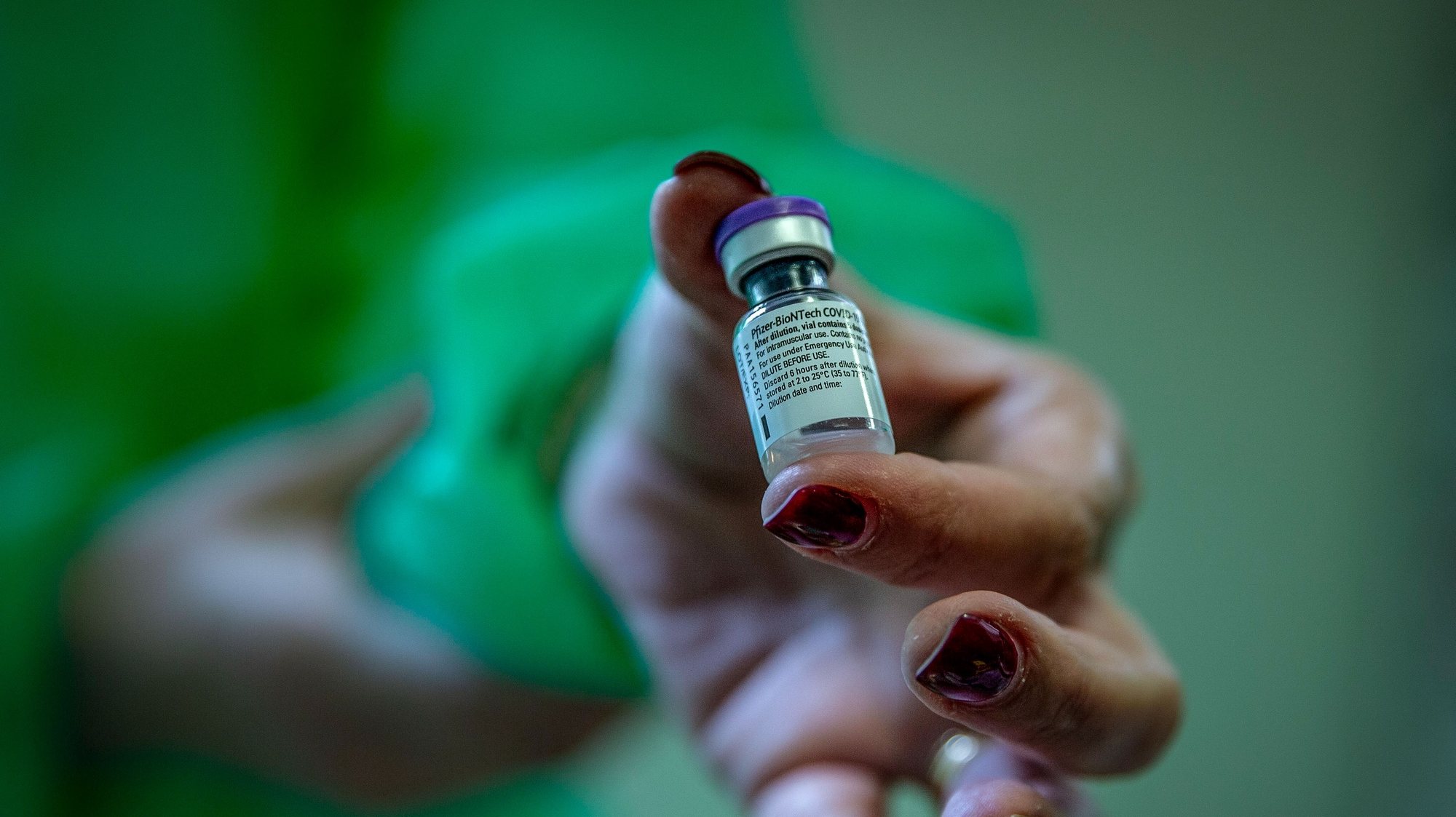 Uma enfermeira mostra a vacina contra a covid-19 durante a vacinação dos profissionais de saúde da Santa Casa Misericórdia de Vila Franca do Campo, em Vila Franca, Ilha de São Miguel, nos Açores, 31  de dezembro de 2020. EDUARDO COSTA /LUSA