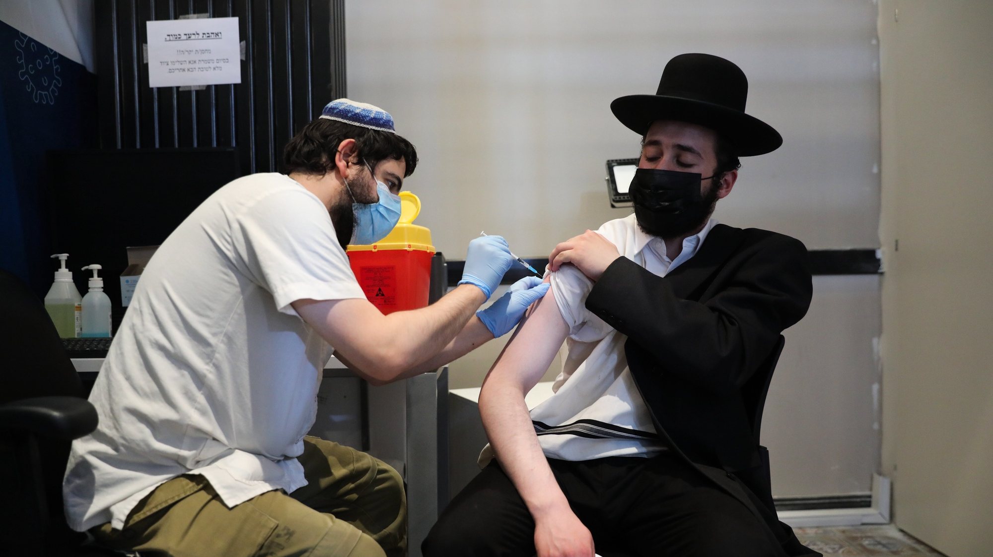 epa09436591 A nurse injects an Ultra Orthodox man with a third shot of COVID-19 vaccine in Jerusalem, Israel, 30 August 2021. Israel launched a campaign to offer a third Covid-19 vaccine dose for people over 30 who received a second shot at least five months ago after infections were reportedly increasing in the country  EPA/ABIR SULTAN