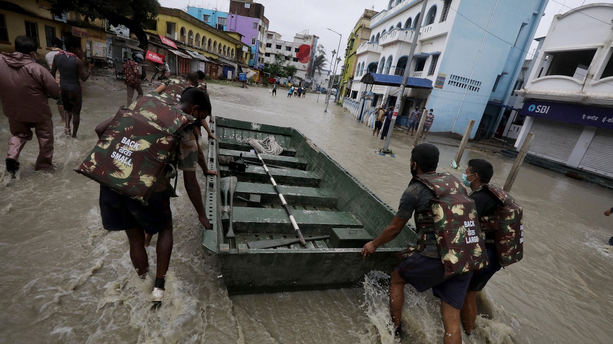epa09228341 Indian Army personel carry a boat to rescue people amid floods as Cyclone Yaas makes landfall in Digha, near the Bay of Bengal, south of Kolkata, India, 26 May 2021. The Odisha and Bengal governments started the evacuation of at-risk areas, as Cyclone Yaas hits the eastern coast of India.  EPA/PIYAL ADHIKARY