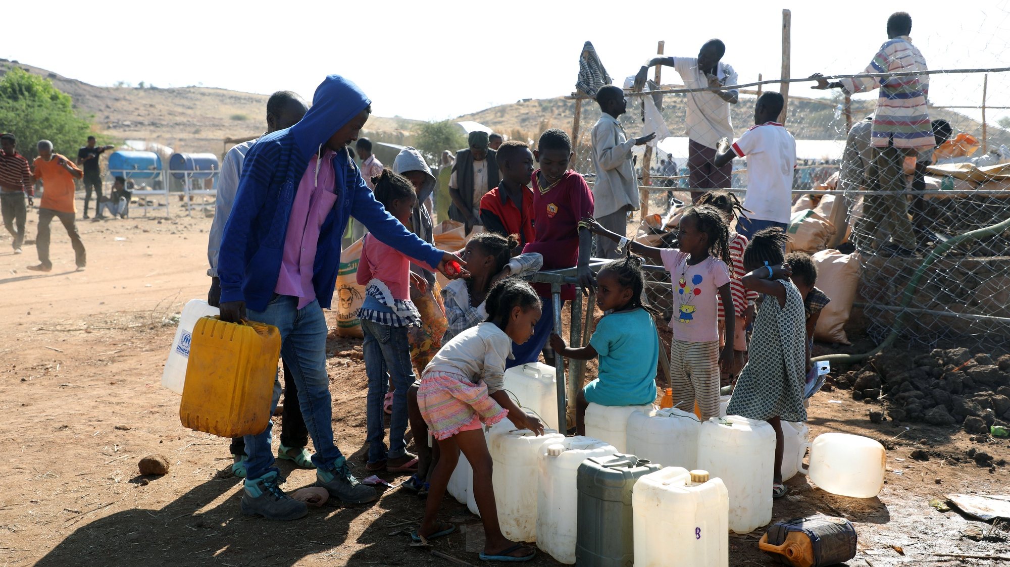 epa08849887 Children collect water at Um Rakuba refugee camp in the state of al-Qadarif (also known as Gedaref), Sudan, 28 November 2020. The number of refugees in this camp reached nearly 10,000 refugees who crossed the border from Ethiopia to Sudan to escape the conflict in Tigray region of Ethiopia.  EPA/MOHAMMED ABU OBAID