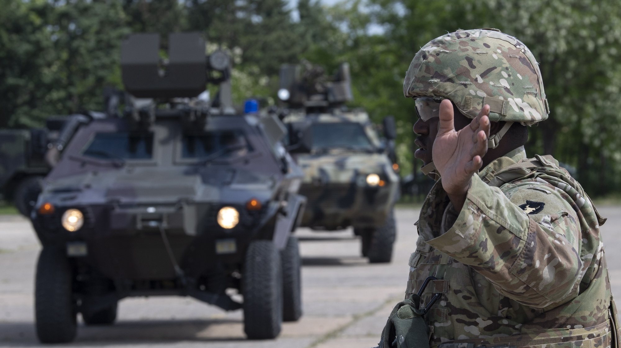 epa10643505 A US soldier gestures to military vehicles during the presentation of military vehicles and equipment Air/Ground Static Display that will participate in the exercise &#039;Immediate Response 23&#039; at the sports airport &#039;Ajitepe&#039;, near Kumanovo, North Macedonia, 21 May 2023. The &#039;Immediate Response 23&#039; exercise, which is part of the largest multi-national joint exercise &#039;Defender Europe 23&#039;, is to take place from 22 May to 02 June primarily in the Balkan region.  EPA/GEORGI LICOVSKI