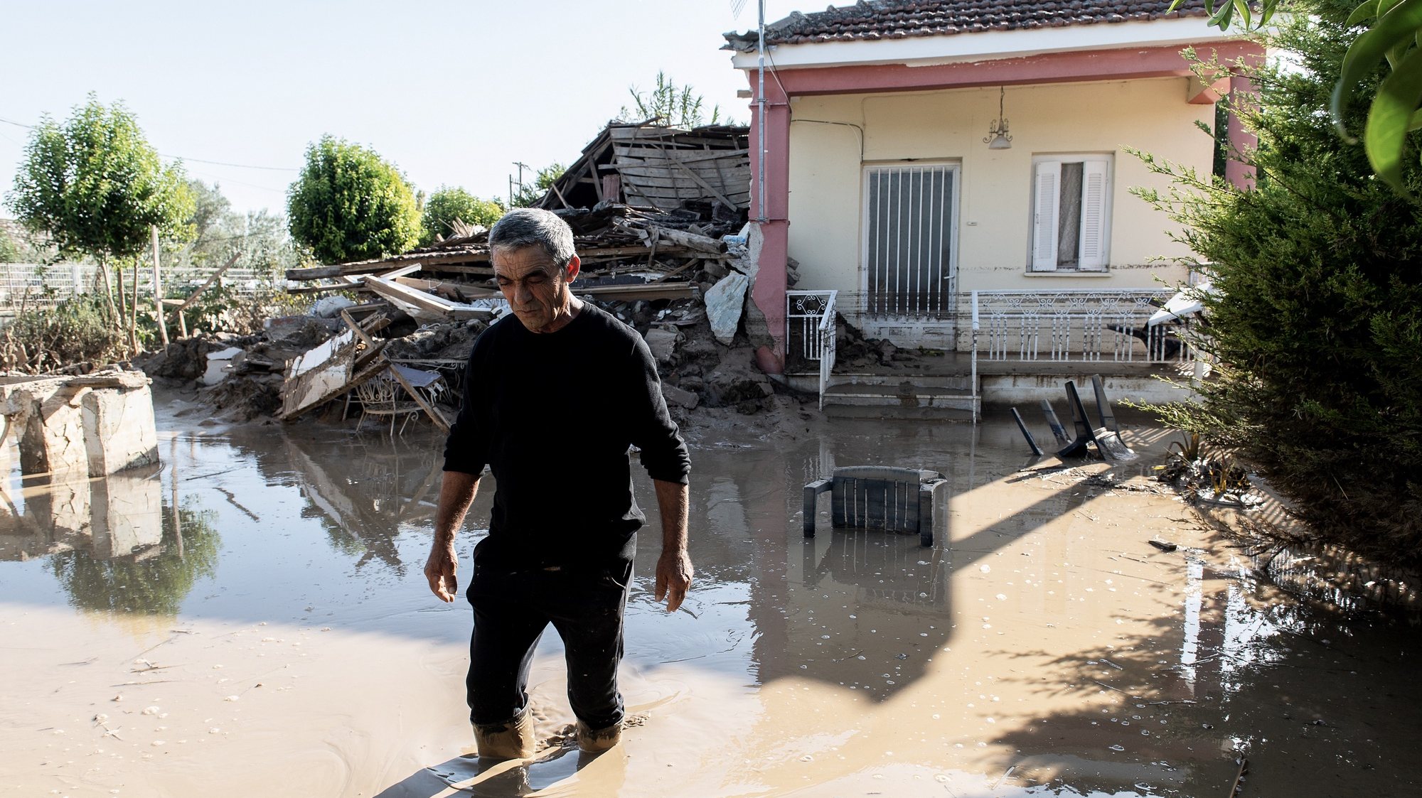 epa10853963 A resident wades through water and mud in his flooded yard, in the village of Sotirio, near Larissa, after storm &#039;Daniel&#039; swept across central Greece, 10 September 2023 (issued 11 September 2023). Entire areas of the regional units of Larissa, Karditsa and Trikala have been turned into a lagoon of mud due to the storm Daniel as rescues of trapped citizens continue. The death toll from floods in Greece has risen to 15.  EPA/HATZIPOLITIS NICOLAOS