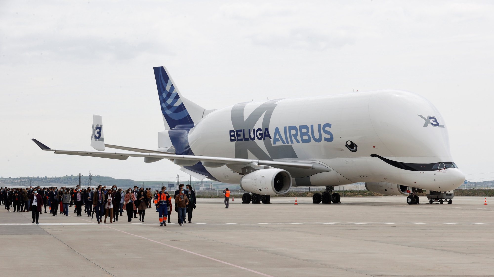 epa09136831 Several guests walk past an Airbus Beluga XL (Airbus A330-700L) aircraft during the opening of Airbus Defense and Space Campus, in the town of Getafe, outside Madrid, Spain, 15 April 2021.  EPA/Chema Moya