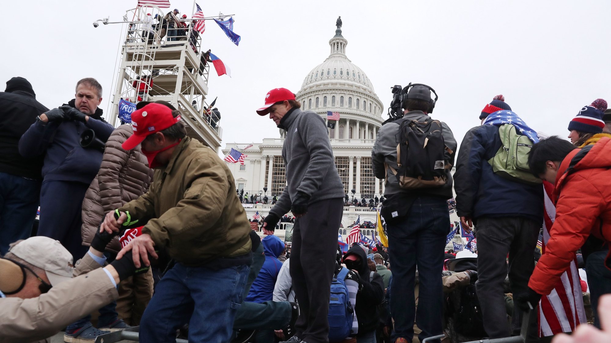 epa08923901 Pro-Trump protesters climb over a barricade while storming the grounds of the West Front of the US Capitol, in Washington, DC, USA, 06 January 2021. Right-wing conservative groups are protesting against Congress counting the electoral college votes. Dozens of state and federal judges have shot down challenges to the 2020 presidential election, finding the accusations of fraud to be without merit.  EPA/MICHAEL REYNOLDS