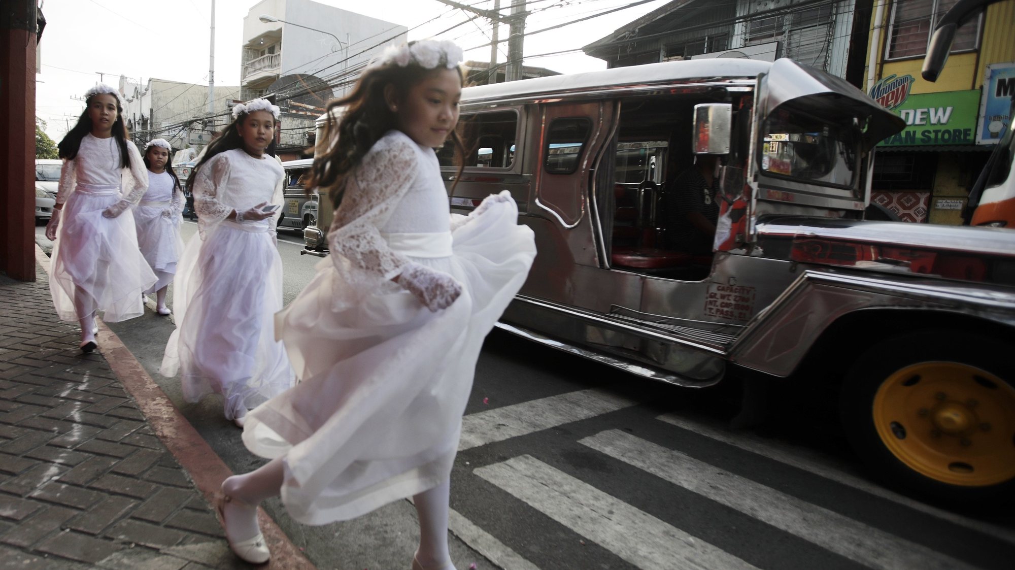 Crianças filipinas vestidas de noivas a correr na rua