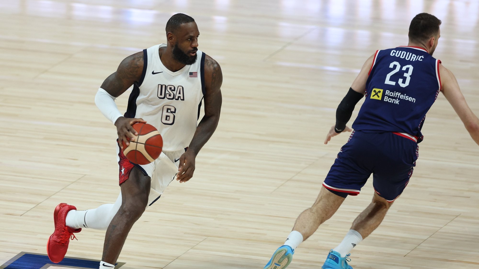 epa11483956 LeBron James (L) of the USA and Marko Guduric of Serbia in action during the 2024 USA Basketball Showcase game between USA and Serbia in Abu Dhabi, United Arab Emirates, 17 July 2024.  EPA/ALI HAIDER