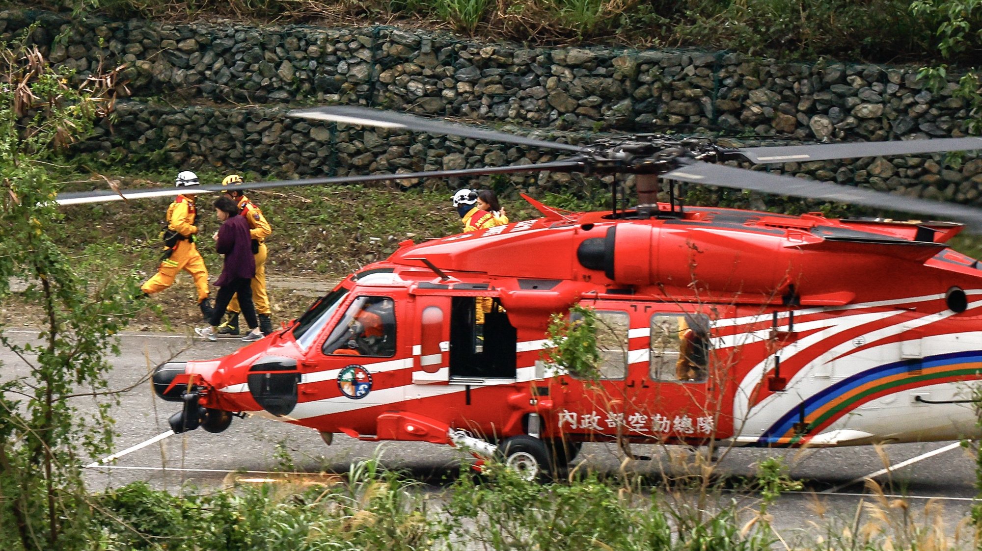 epaselect epa11259963 People are assisted by rescuers after they were brought to safety on a helicopter from a mountainous area, at a temporary car park in Taroko National Park, in Hualien, Taiwan, 05 April 2024. Rescue operations to evacuate people trapped in mountainous areas across Hualien are still underway, after the magnitude 7.4 earthquake on 03 April killed at least ten people and injured more than a thousand individuals.  EPA/DANIEL CENG