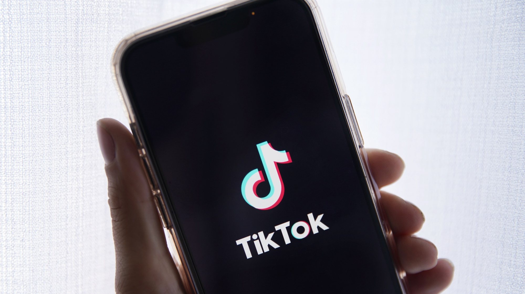 epa10635388 In this photo illustration a person holds up a cell phone with the TikTok logo displayed in Los Angeles, California, USA, 17 May 2023. Govenor Greg Gianforte of Montana signed a measure that bans the TikTok app in the state.  EPA/CAROLINE BREHMAN